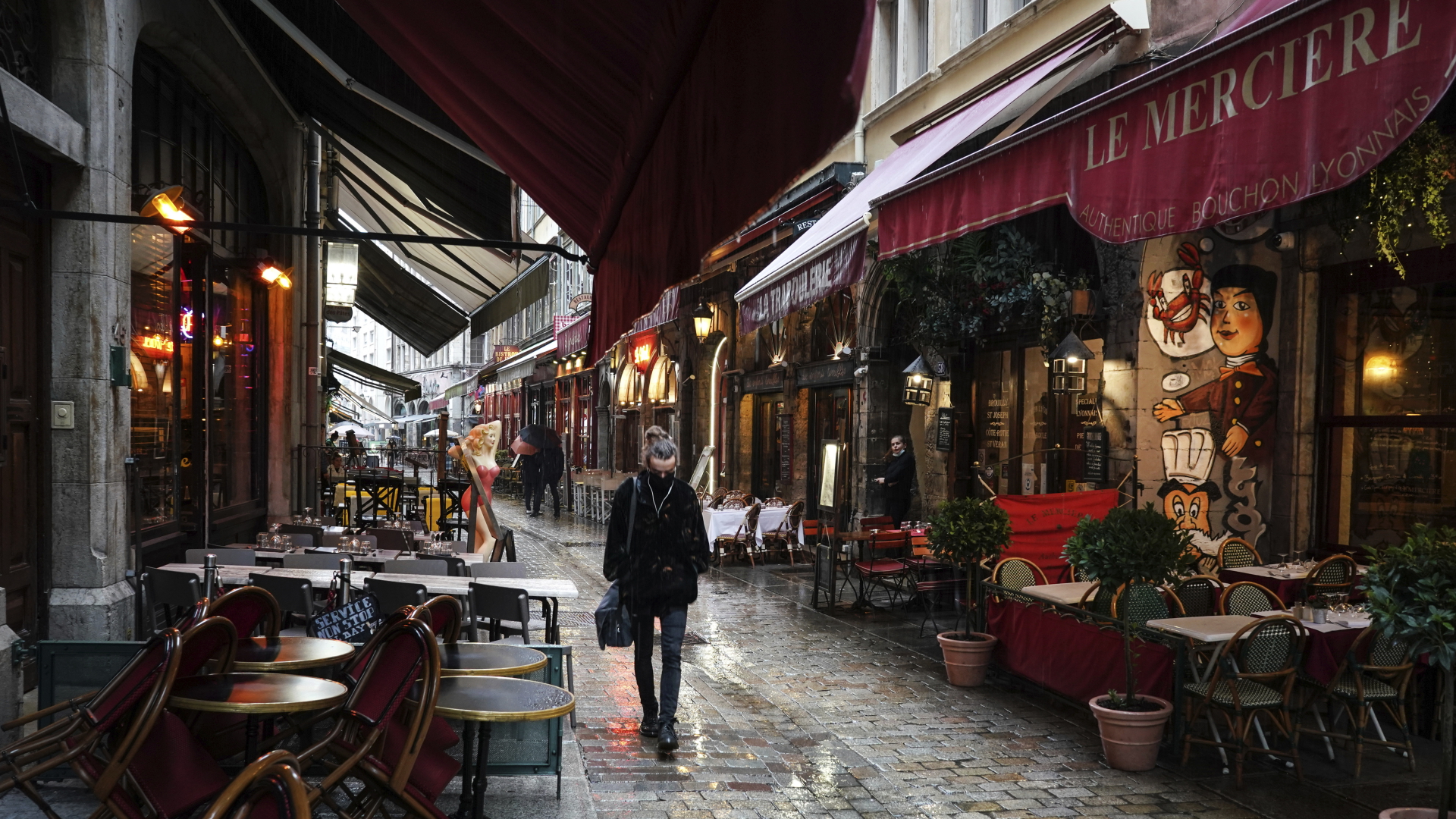 Eine Frau geht an leeren Restaurants im Zentrum von Lyon vorbei.  | dpa