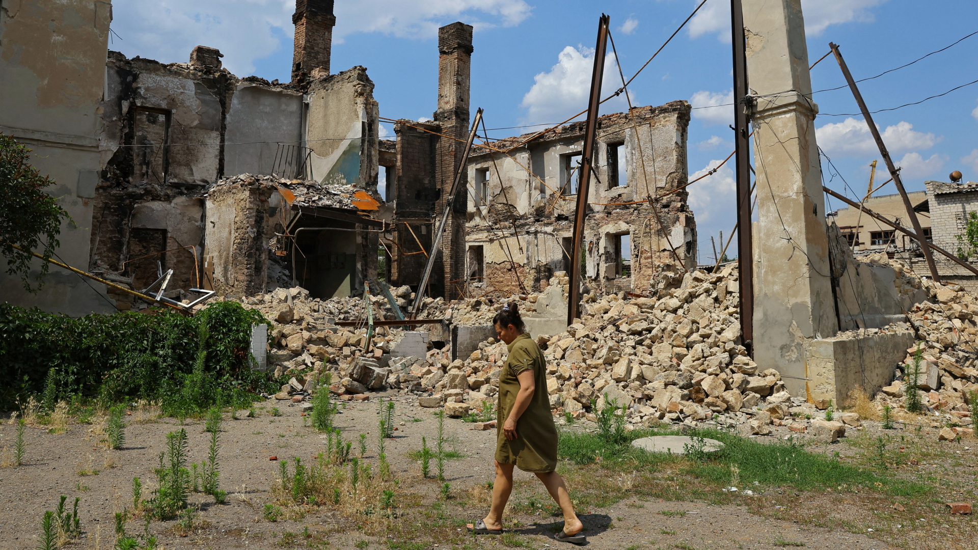 Eine Frau vor einem zerstörten Haus in Lysychansk in der Region Luhansk