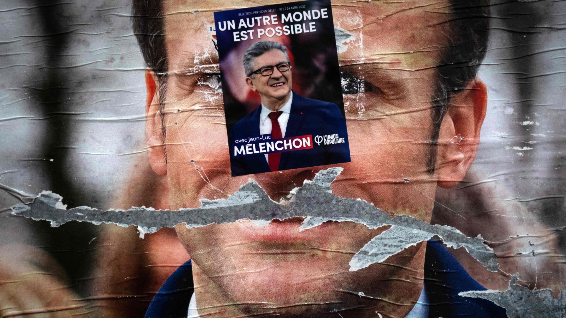 Ein Plakat von Frankreichs Präsident Macron ist mit einem Aufkleber des unterlegenen Linken Mélenchon überklebt | AFP