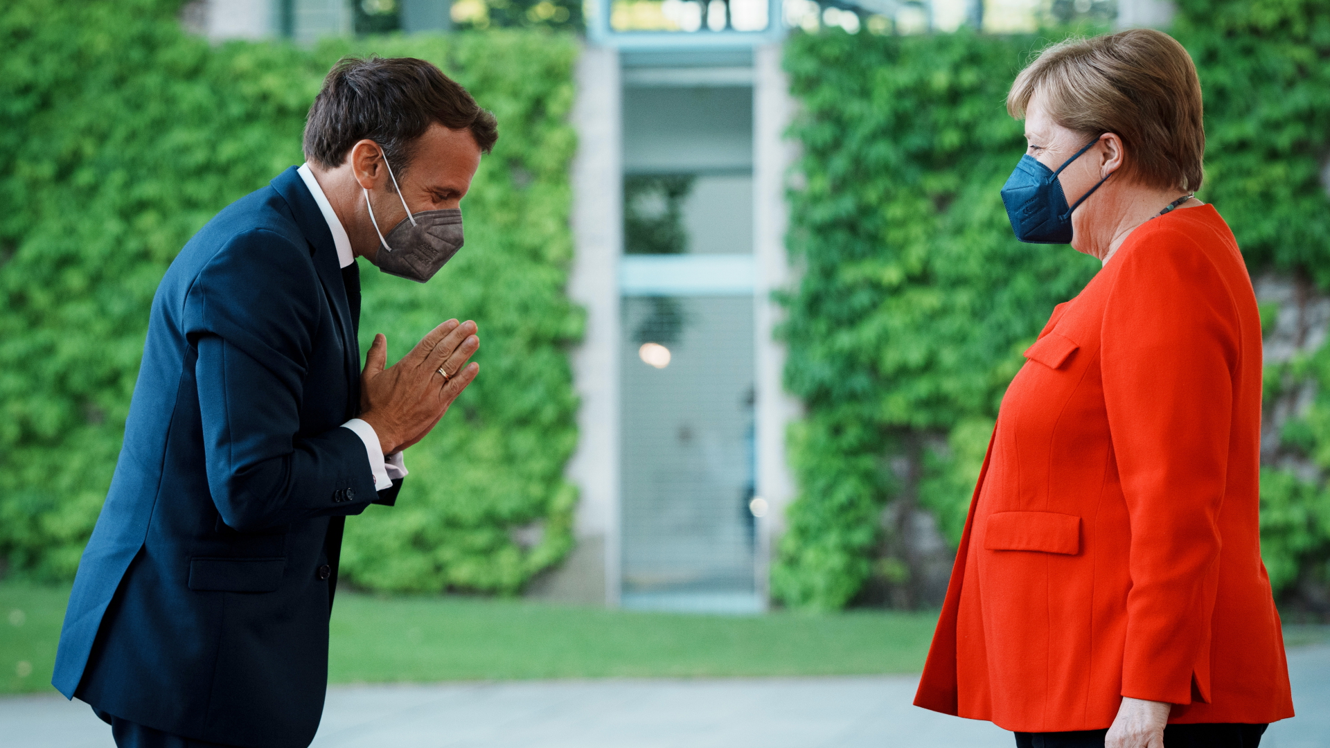 Macron begrüßt Merkel mit einer Verbeugung im Juni 2021 in Berlin | dpa