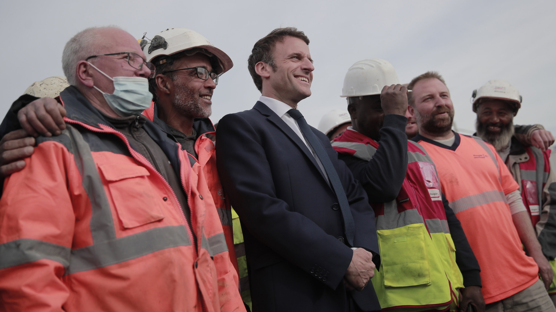 Frankreichs Präsident Macron stellt sich bei einem Wahlkampftermin in  Denain für ein Bild mit Arbeitern hin. | AP