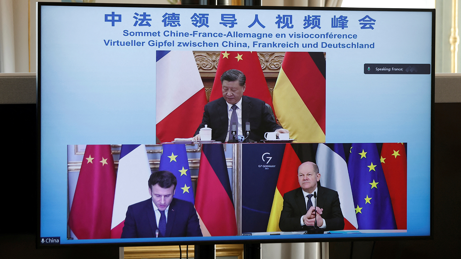 Ein Monitor zeigt Emmanuel Macron, Olaf Scholz und Xi Jinping. | dpa