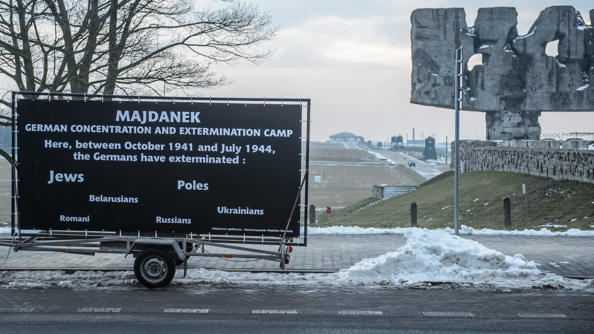 Ein Plakat mit der Aufschrift "Majdanek Deutsches Konzentrations- und Vernichtungslager" vor der Gedenkstätte Majdanek. Die Aktion ist ein Teil der laufenden Web-Kampagne #DeutscheDeathCamps. | Bildquelle: dpa
