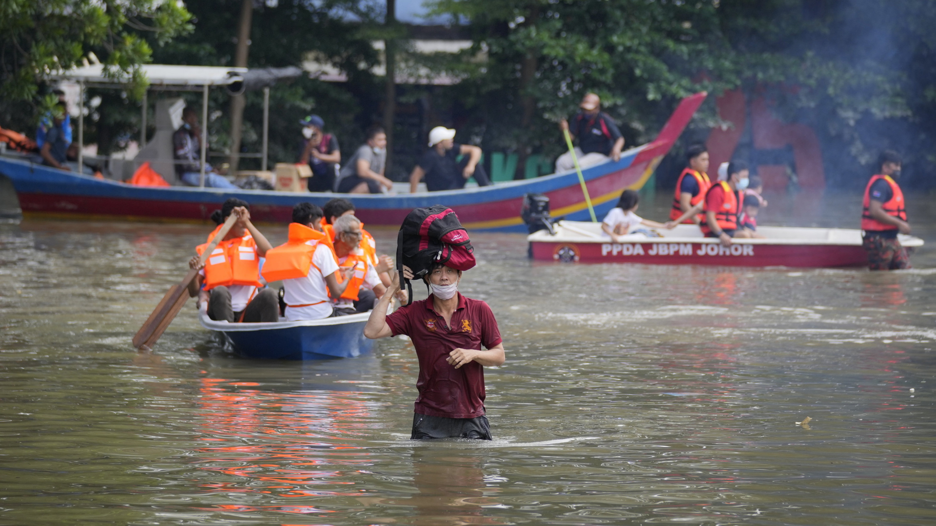 Rettungskräfte bringen Bewohner auf einem Boot aus einem überfluteten Wohngebiet am Stadtrand von Kuala Lumpur in Sicherheit. | AP