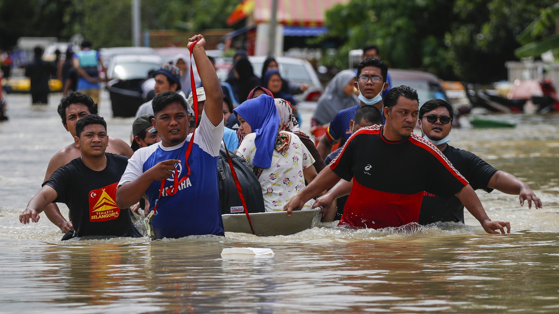 Menschen waten durch hüfthohes Wasser in einem Vorort von Kuala Lumpur, Malaysia. | EPA