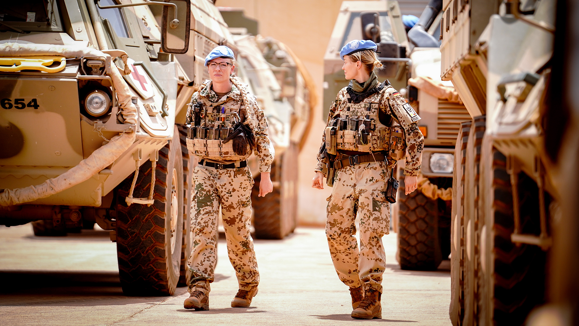 Soldatinnen zwischen Fahrzeugen in  Camp Castor in Gao, Mali
