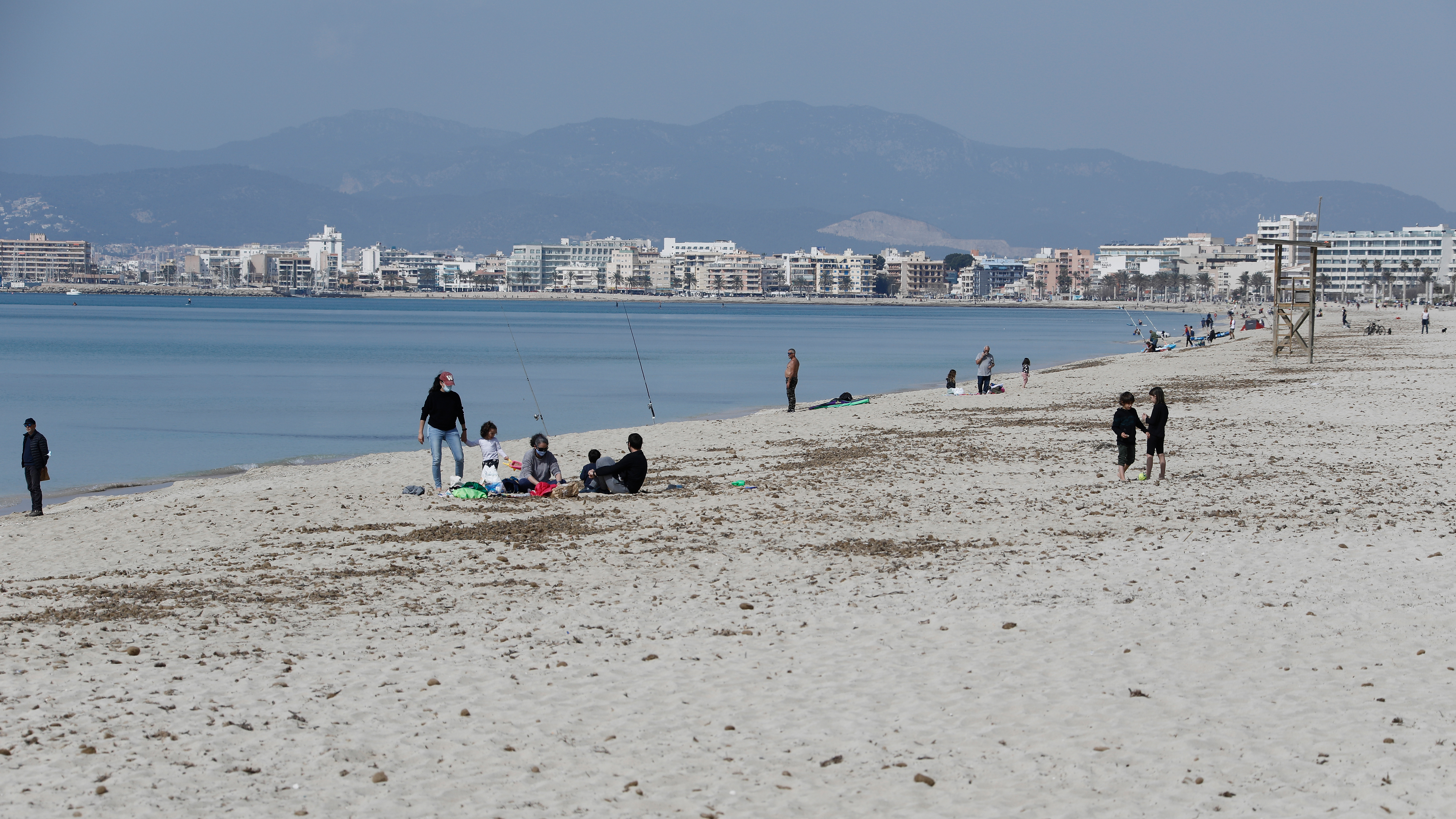 Besucher gehen am Strand von El Arenal auf Mallorca spazieren. | dpa