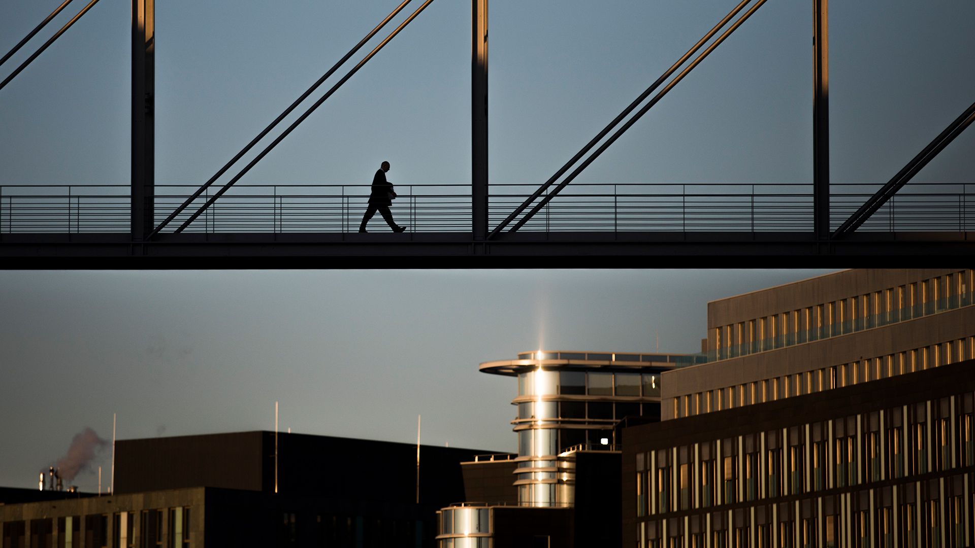 Ein Mann läuft zur Abendstunde über die Brücke zwischen Marie-Elisabeth-Lüders-Haus und Paul-Löbe-Haus.
