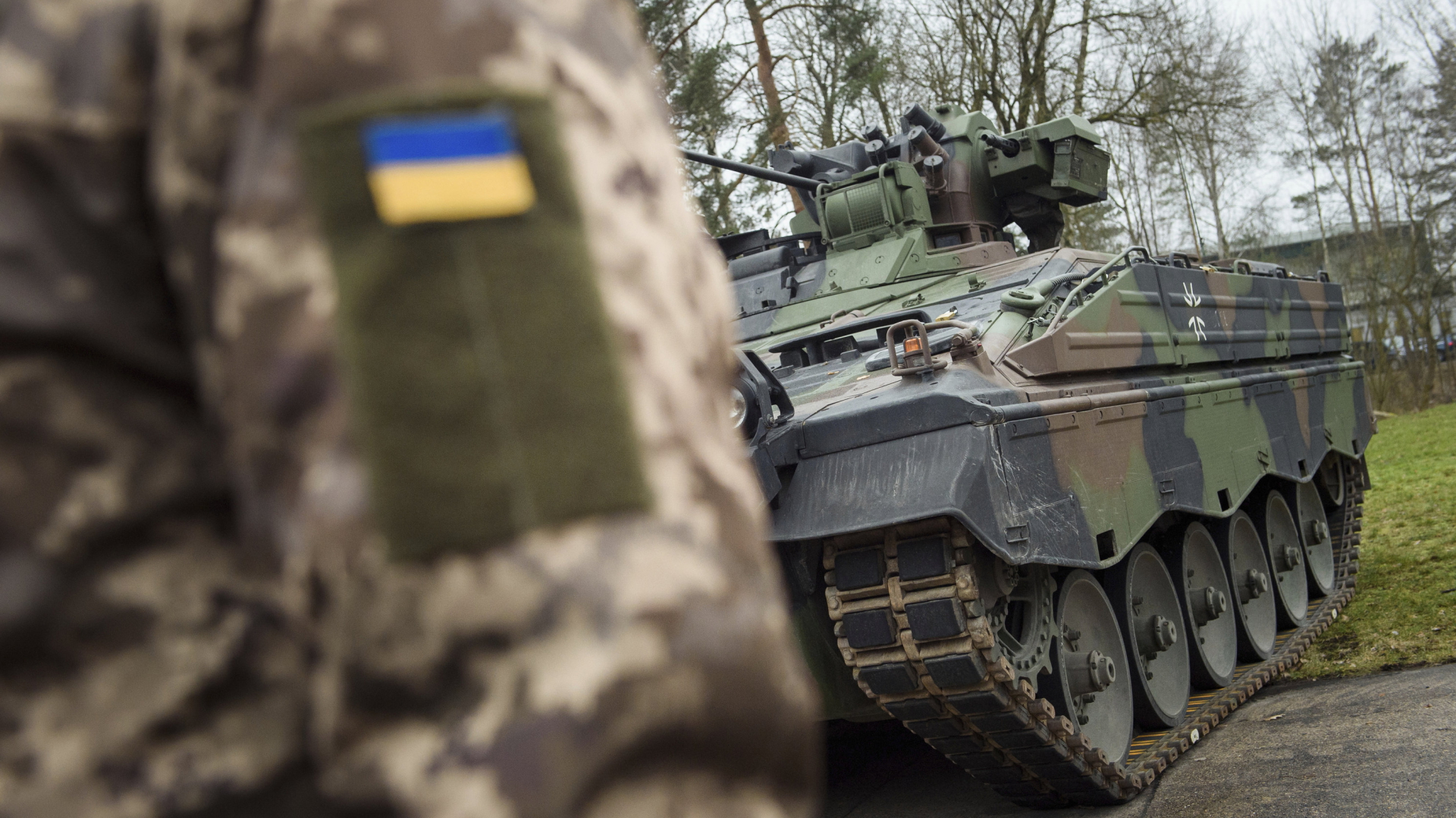 Ein ukrainischer Soldat steht vor einem "Marder"-Schützenpanzer bei einem Training in Munster.