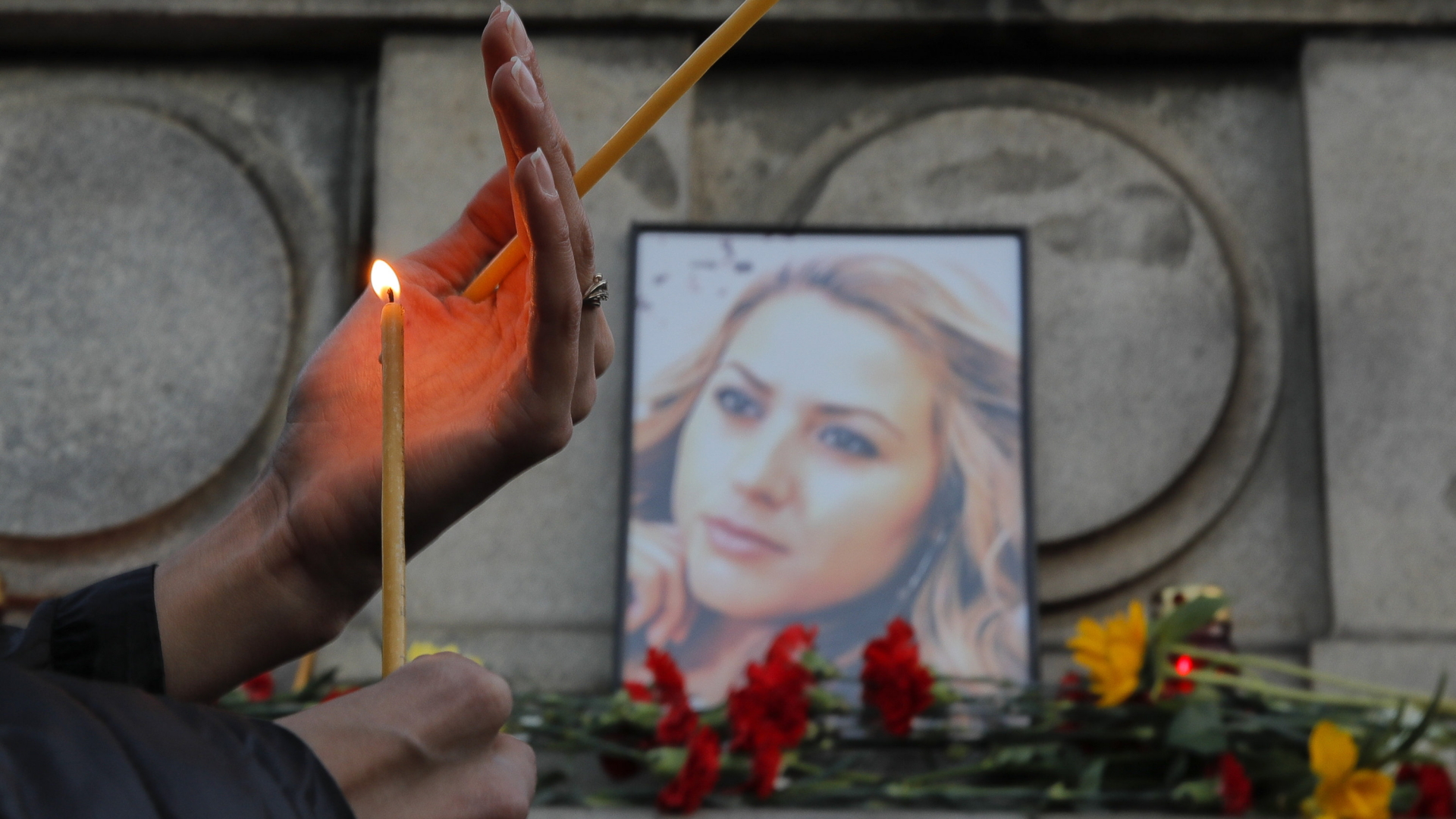 Eine Kerze wird vor einem Porträt von WiktoijaMarinowa