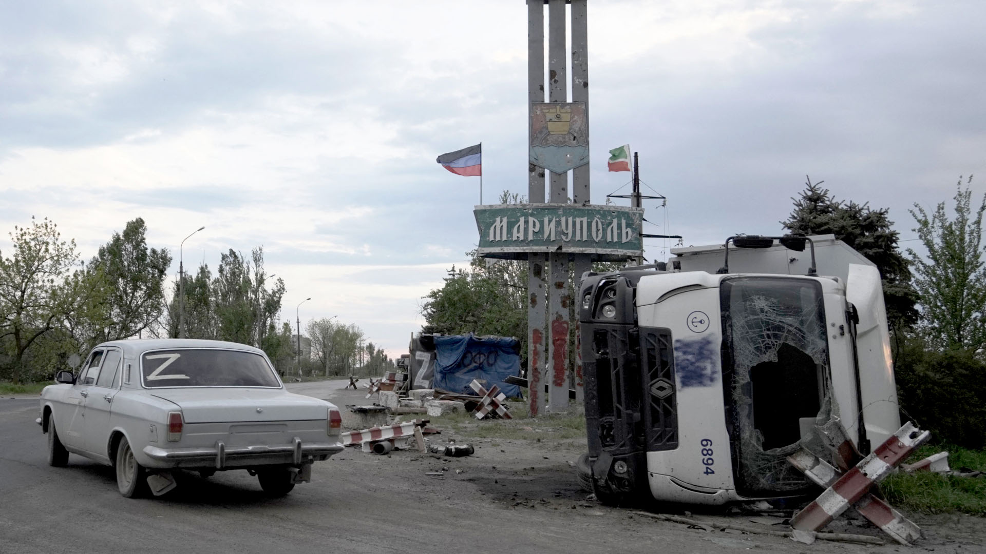 Autos und Z-Symbole am Stadteingang von Mariupol. | AFP