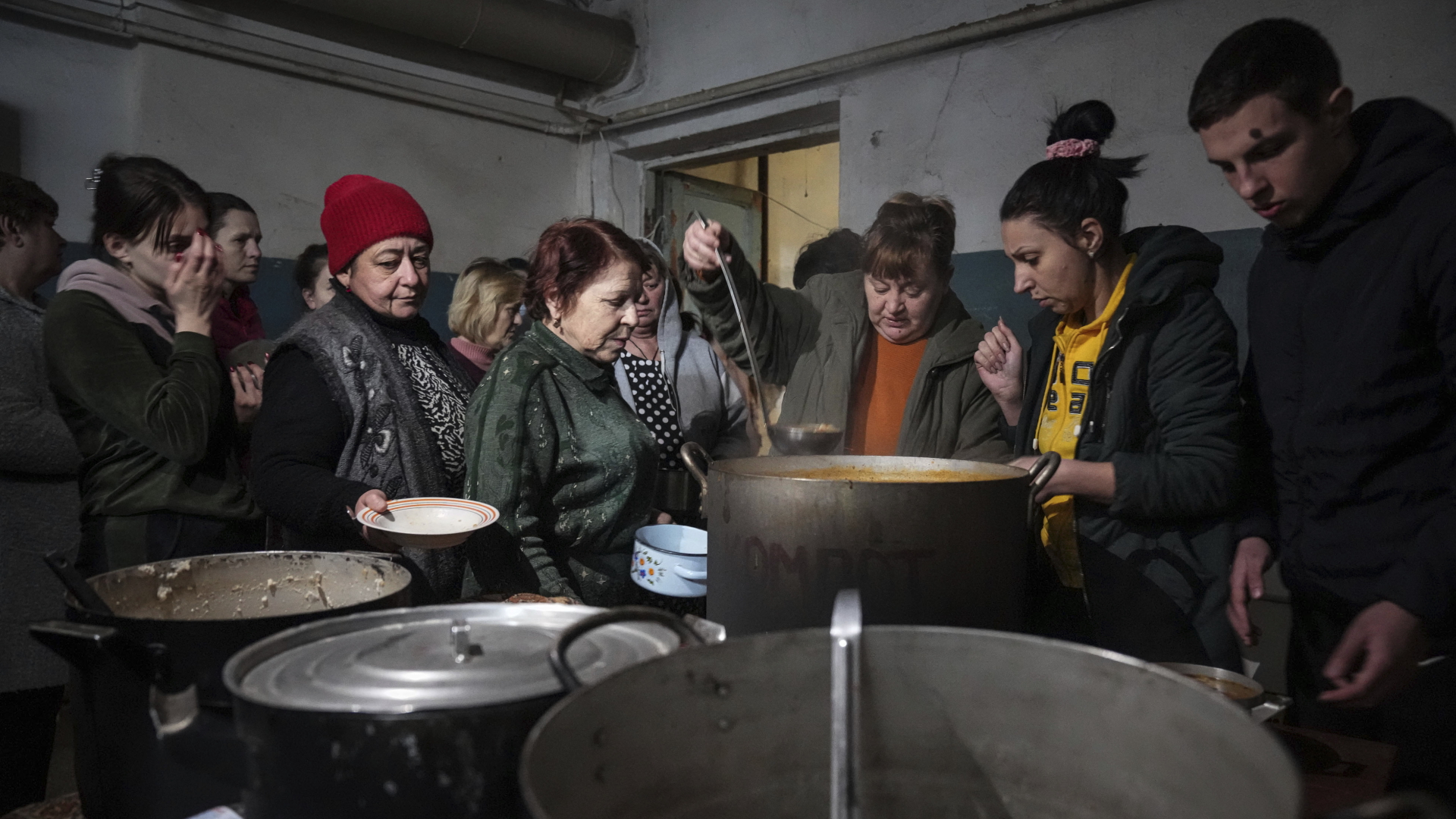 Menschen stehen Schlange, um in einem improvisierten Bunker in Mariupol warmes Essen zu erhalten | dpa