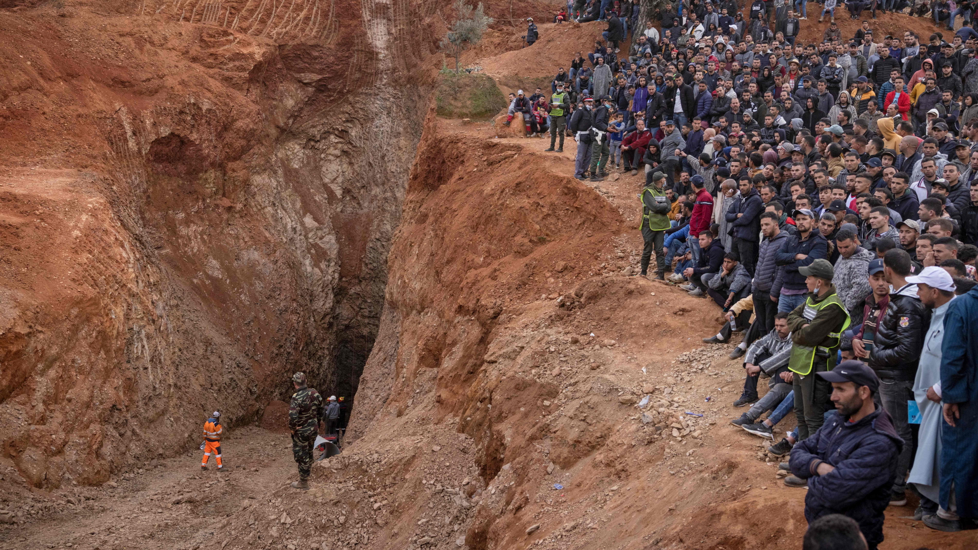 Hunderte Menschen stehen an der Unglücksstelle in Marokko, wo ein Fünfjähriger in einen Brunnenschacht gefallen war. | AFP