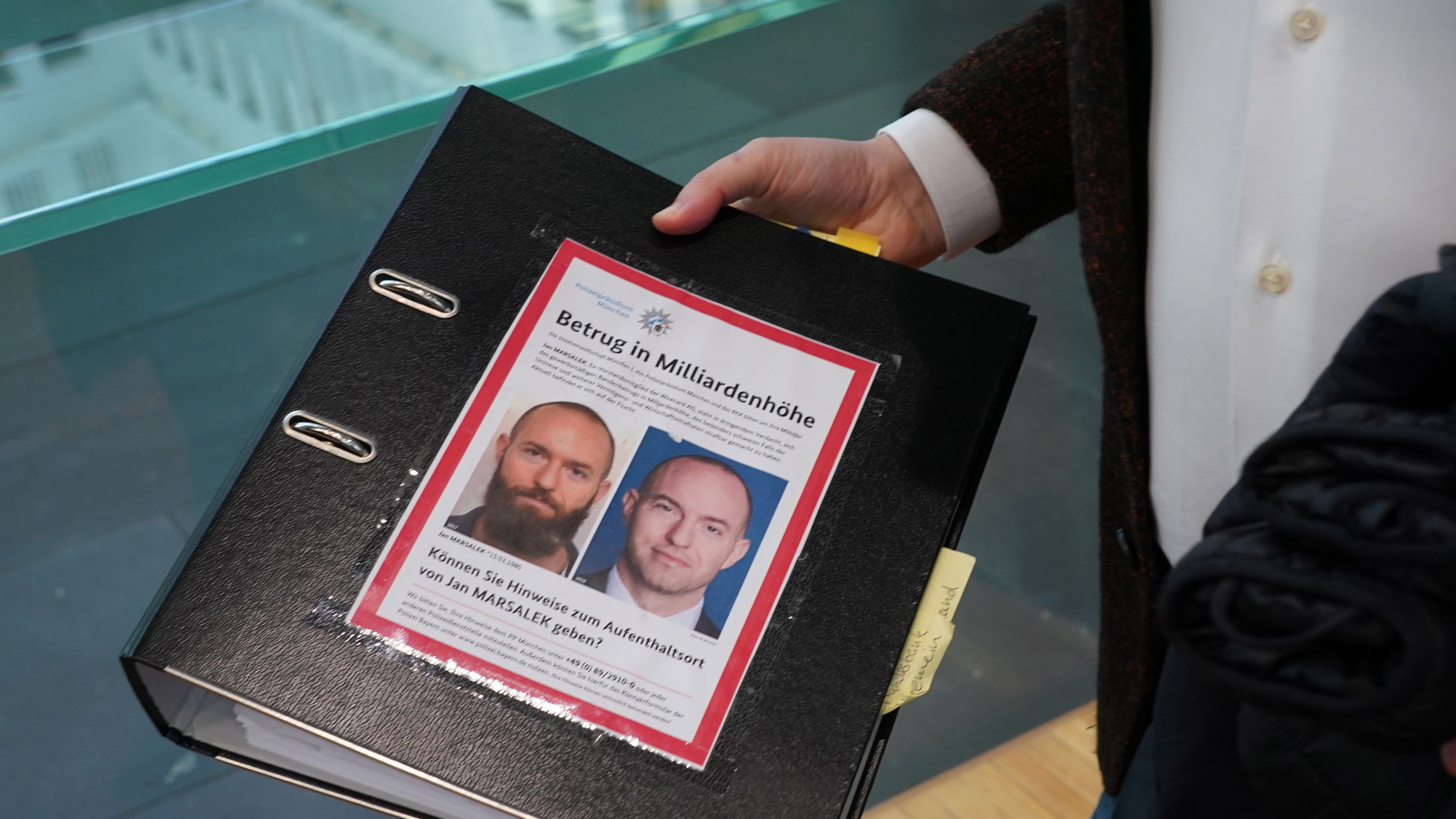 Der Aktenordner des Bundestagsabgeordneten de Masi (Die Linke) mit Fahndungsfotos des früheren Wirecard-Finanzvorstands Jan Marsalek ist im Sitzungssaal zum Bilanzskandal Wirecard im Paul-Löbe-Haus zu sehen. | EPA