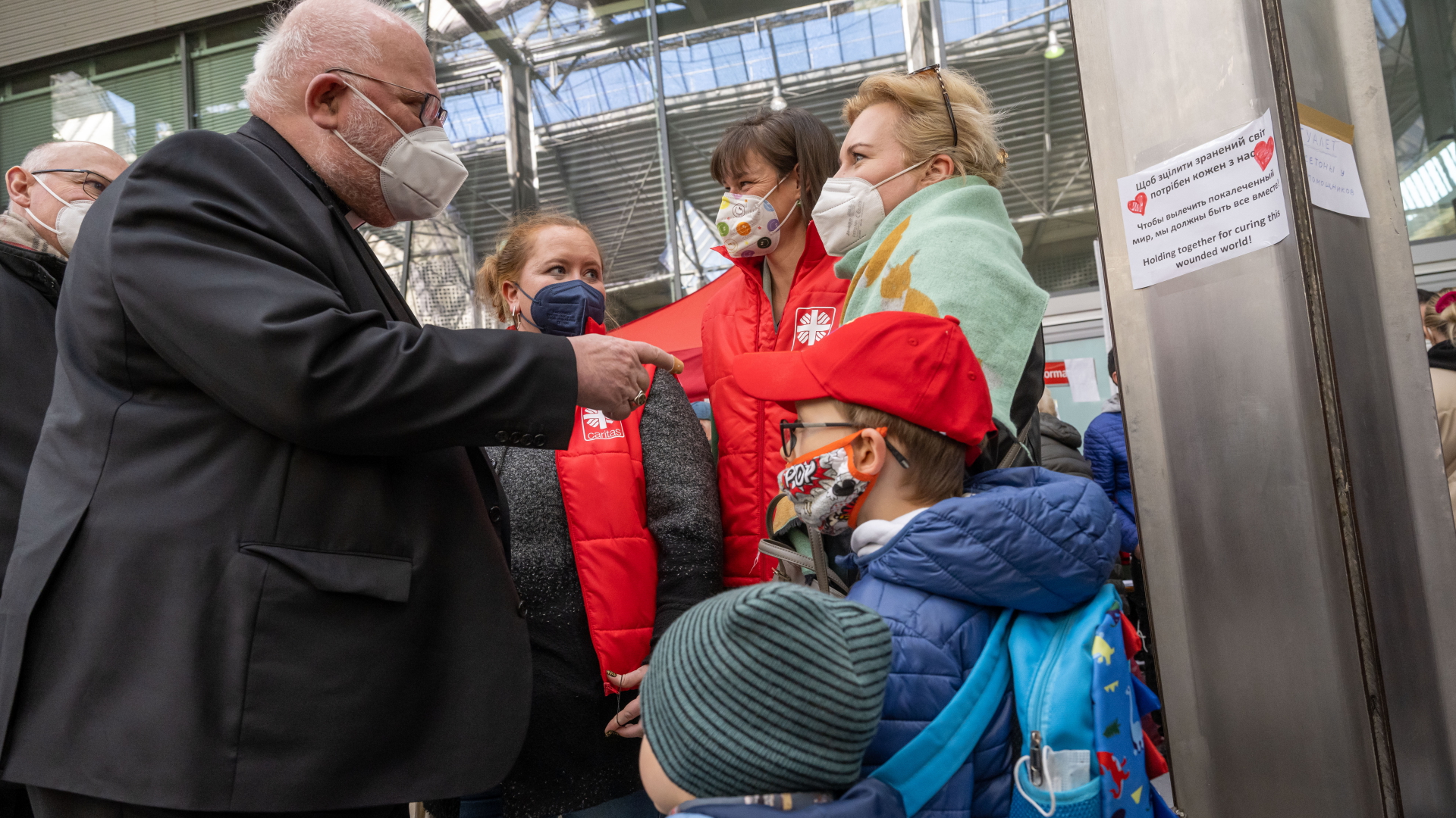 Kardinal Marx spricht mit Flüchtlingen, die aus der Ukraine in München angekommen sind. | dpa
