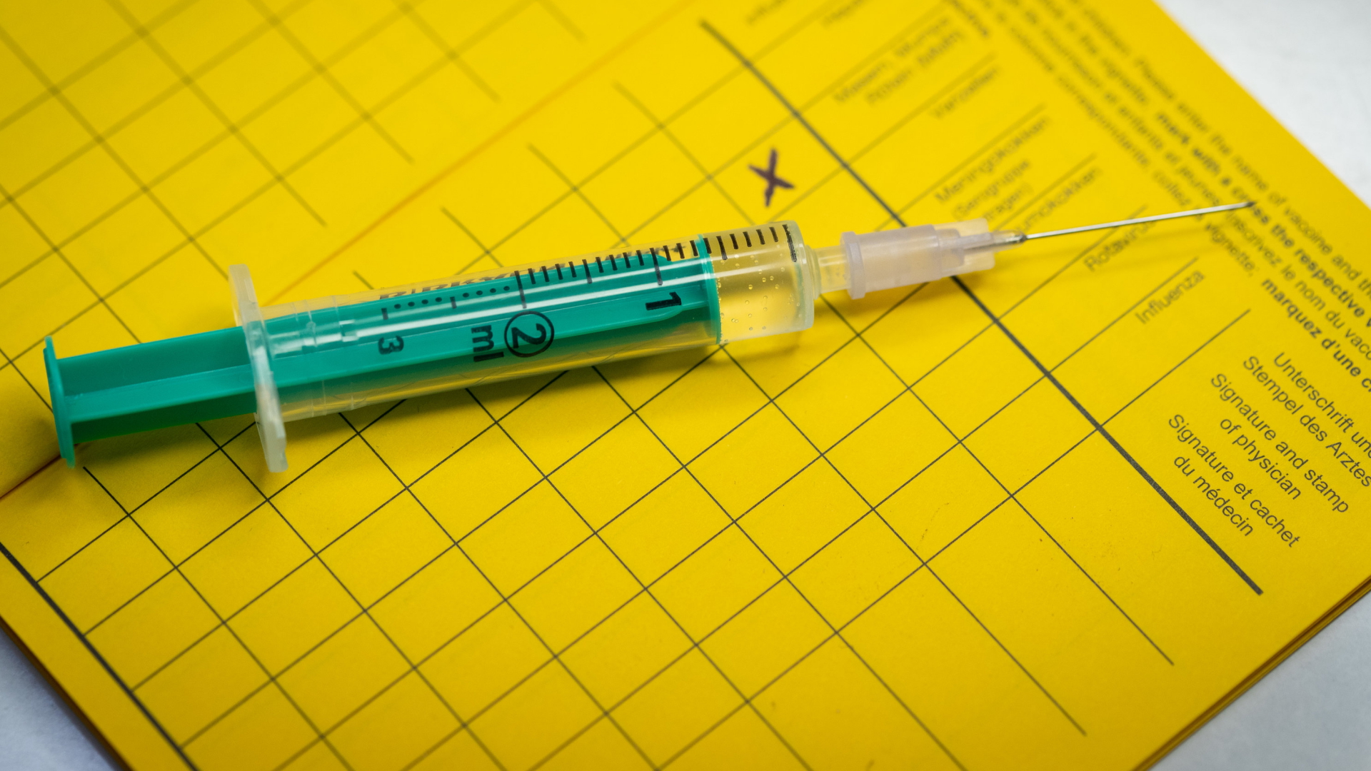 Eine Spritze liegt auf einem Impfpass (Archivbild) | dpa