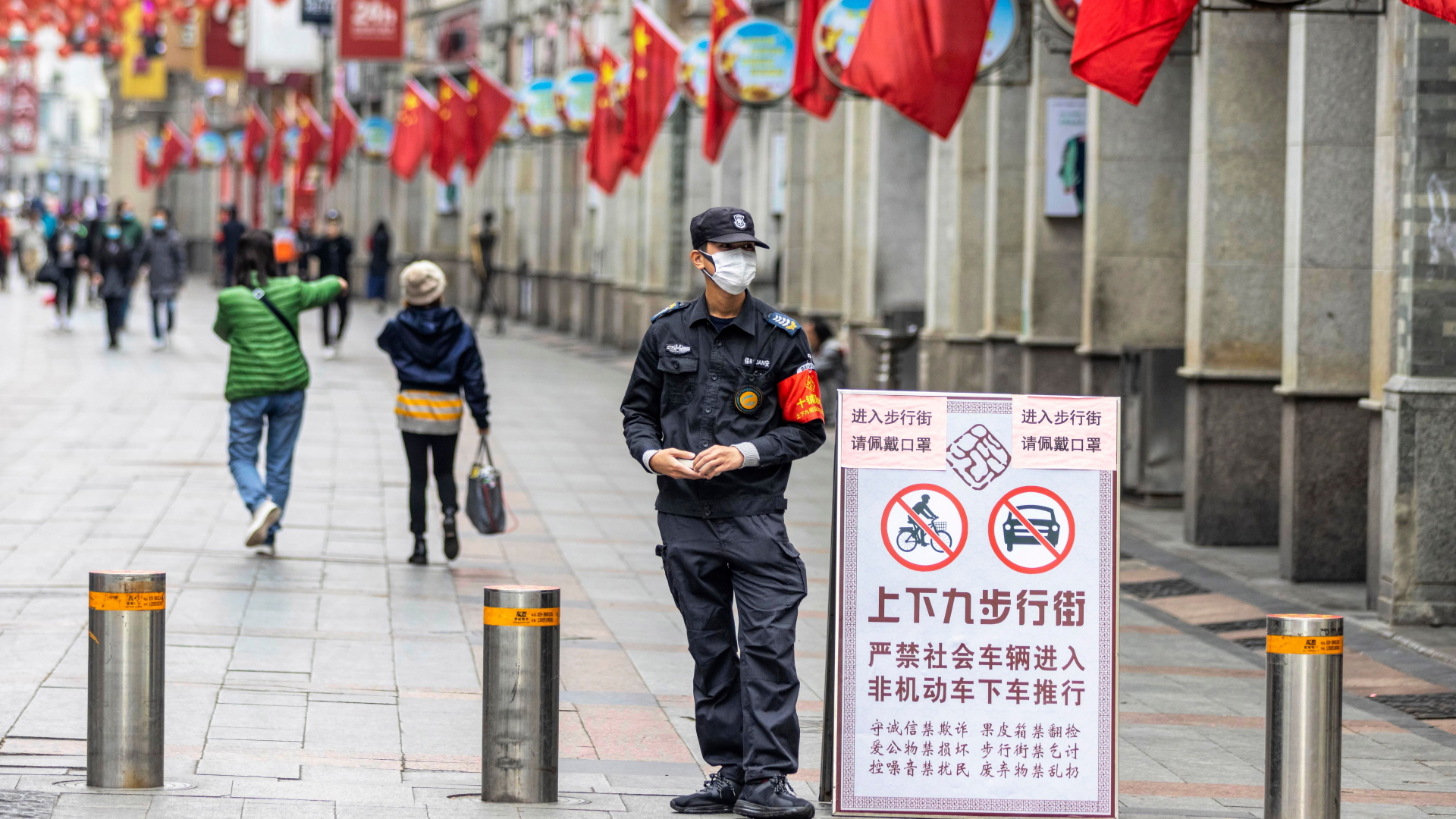 Ein Sicherheitsbeamter in Guangzhou soll verhindern, dass Menschen ohne Gesichtsmaske eine Fußgängerzone betreten. | ALEX PLAVEVSKI/EPA-EFE/REX