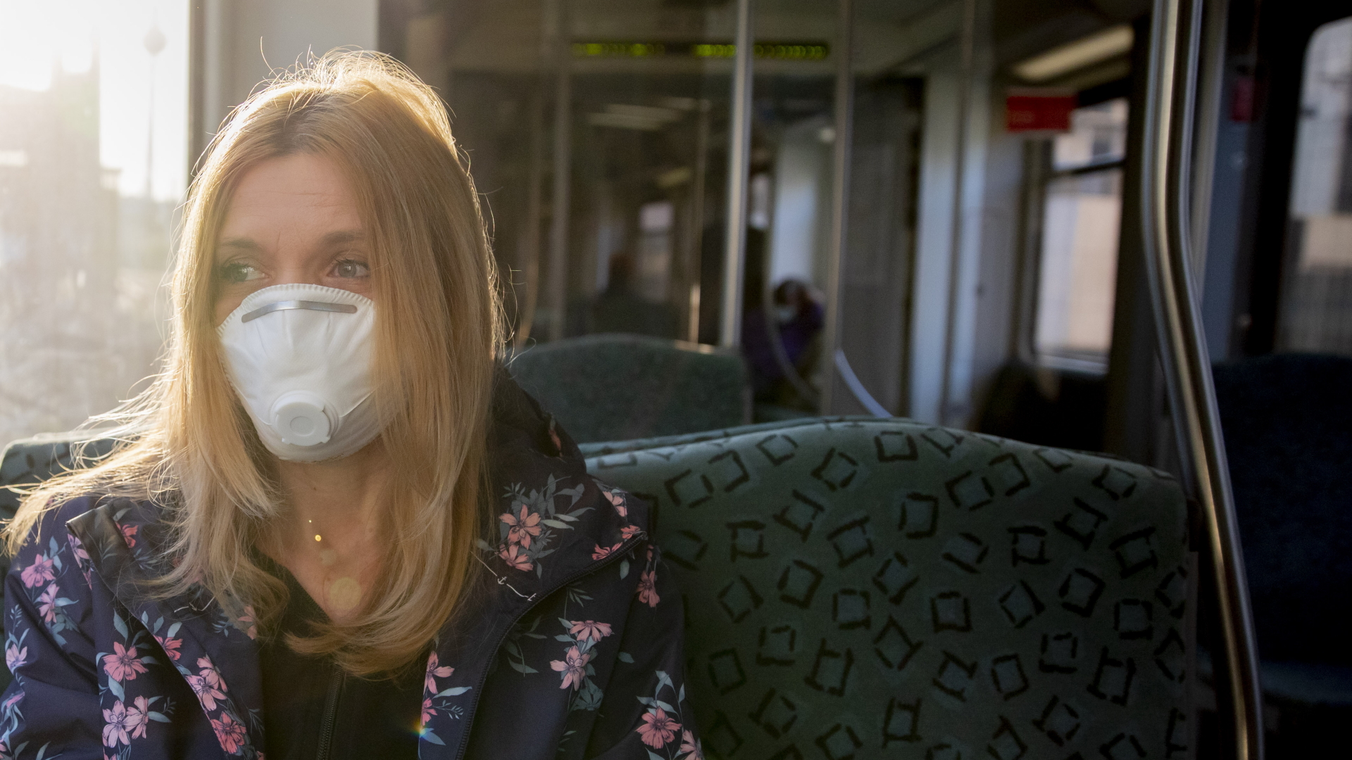 Frau mit Mund- und Nasenschutz in der Bahn | dpa