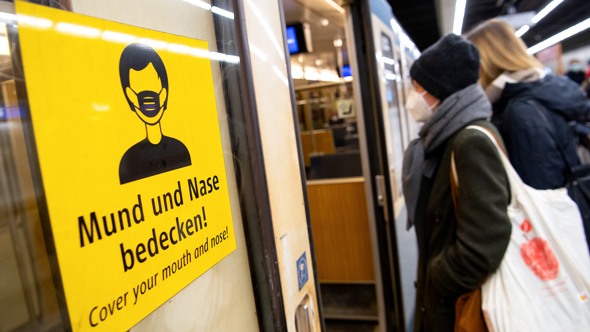 Ein Schild mit der Aufschrift "Mund und Nase bedecken" an einer U-Bahn-Tür | picture alliance/dpa