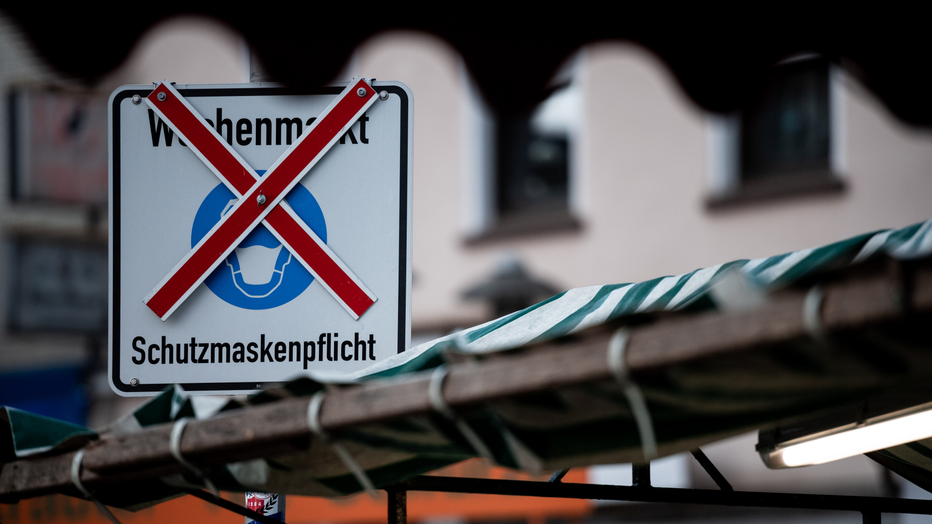 Ein Schild auf einem Wochenmarkt in Oberhausen, das auf die Maskenpflicht hinweist ,ist durchgestrichen. | dpa