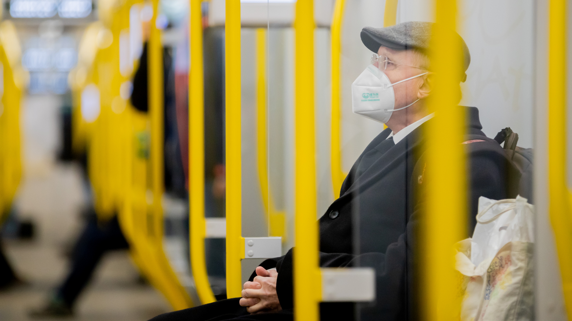 Ein Mann sitzt mit einer Schutzmaske in einer Bahn | dpa