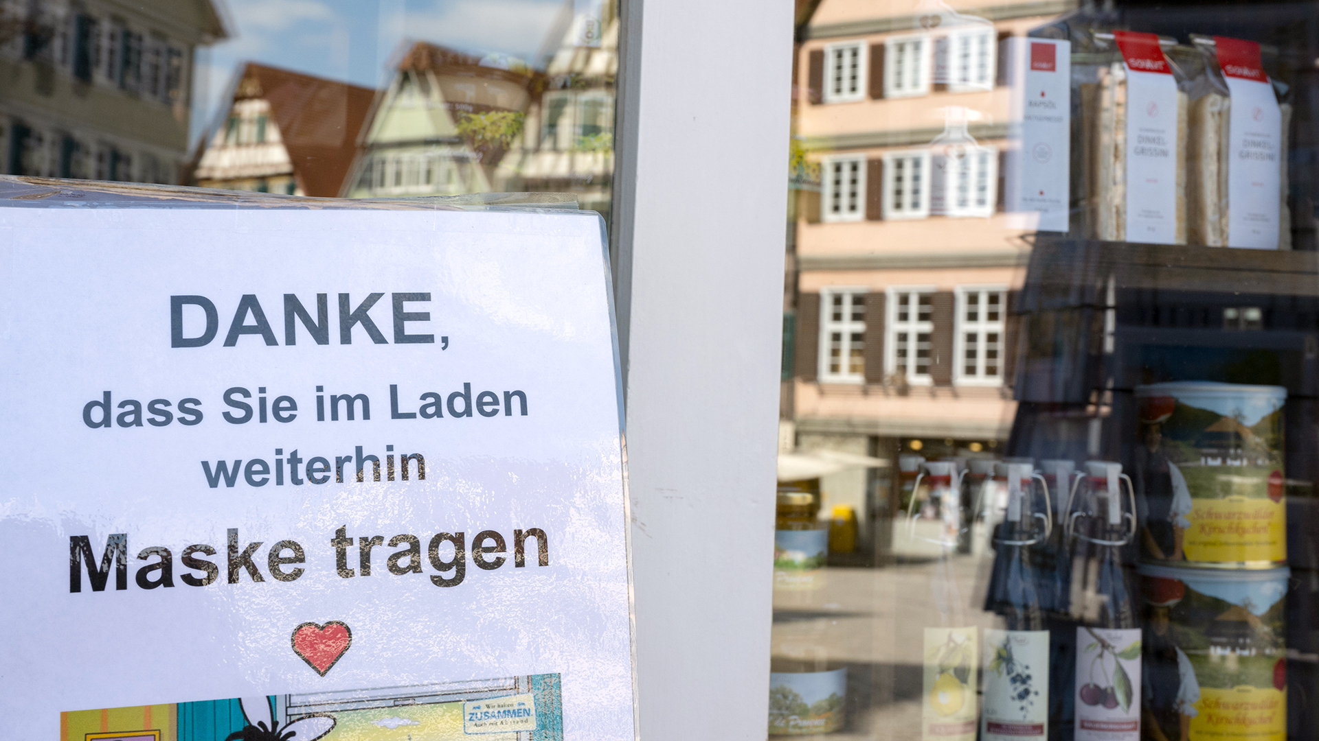 Vor einem Laden in der Innenstadt von Tübingen hängt eine Hinweisschild mit dem die Kunden aufgefordert werden, im Laden auch weiterhin Mund-Nasen-Schutz zu tragen.  | dpa
