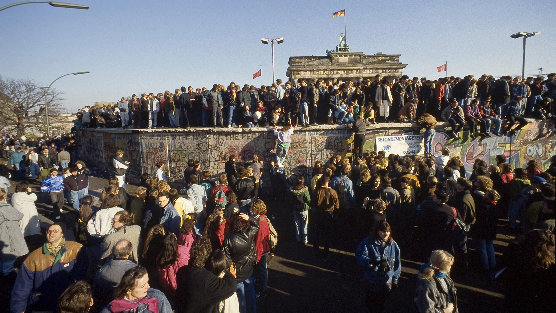 Menschen aus Ost- und West-Berlin sind auf die Mauer am Brandenburger Tor in Berlin geklettert | picture alliance / imageBROKER