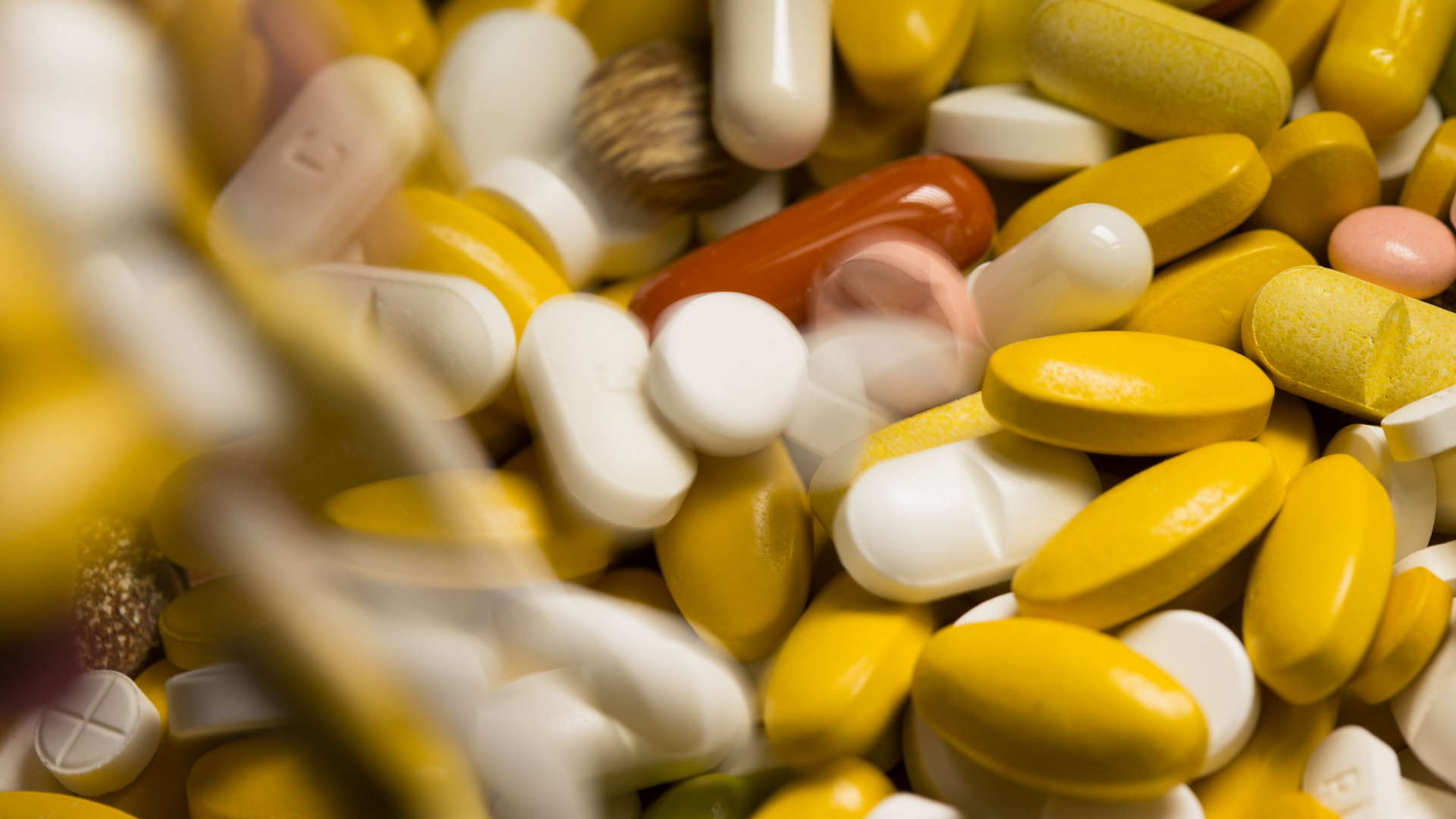 Tabletten, Kapseln und Pillen in verschiedenen Farben liegen in einem Medikamenten-Behälter einer Apotheke.  | Bildquelle: dpa