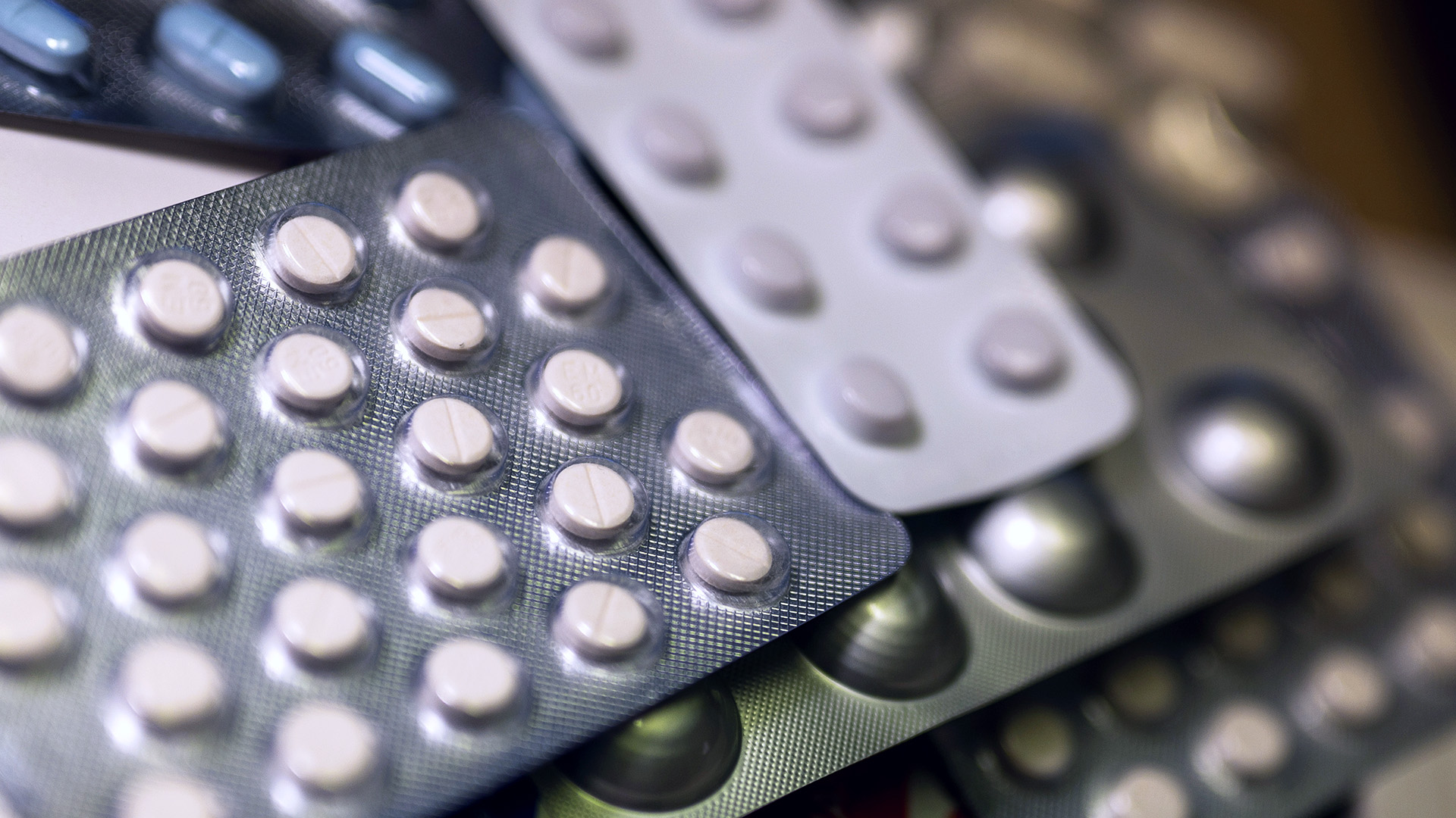 Diverse Medikamentenpackungen liegen auf einem Tisch in einer Apotheke.
