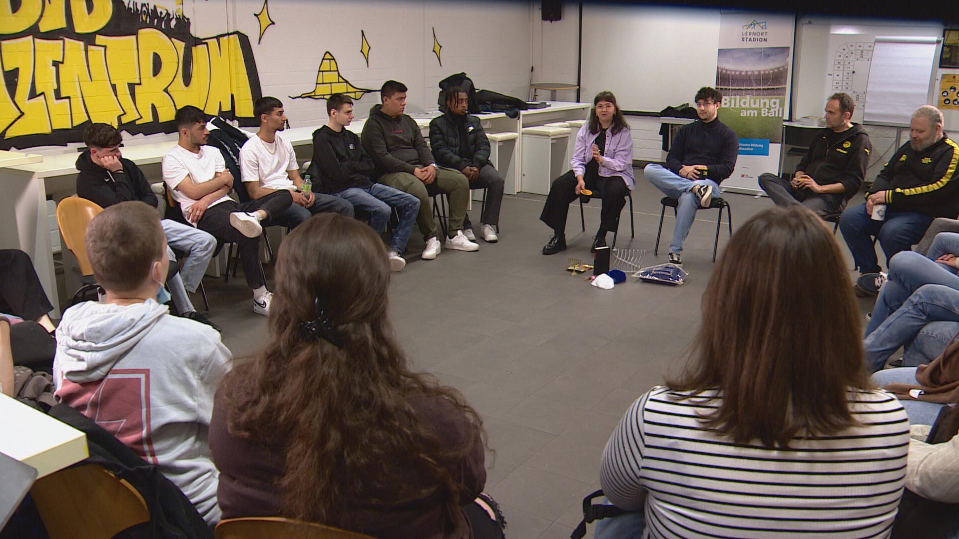 Eine Gruppe überwiegend junger Menschen sitzt in einem Stuhlkreis. | Birgit Virnich/WDR