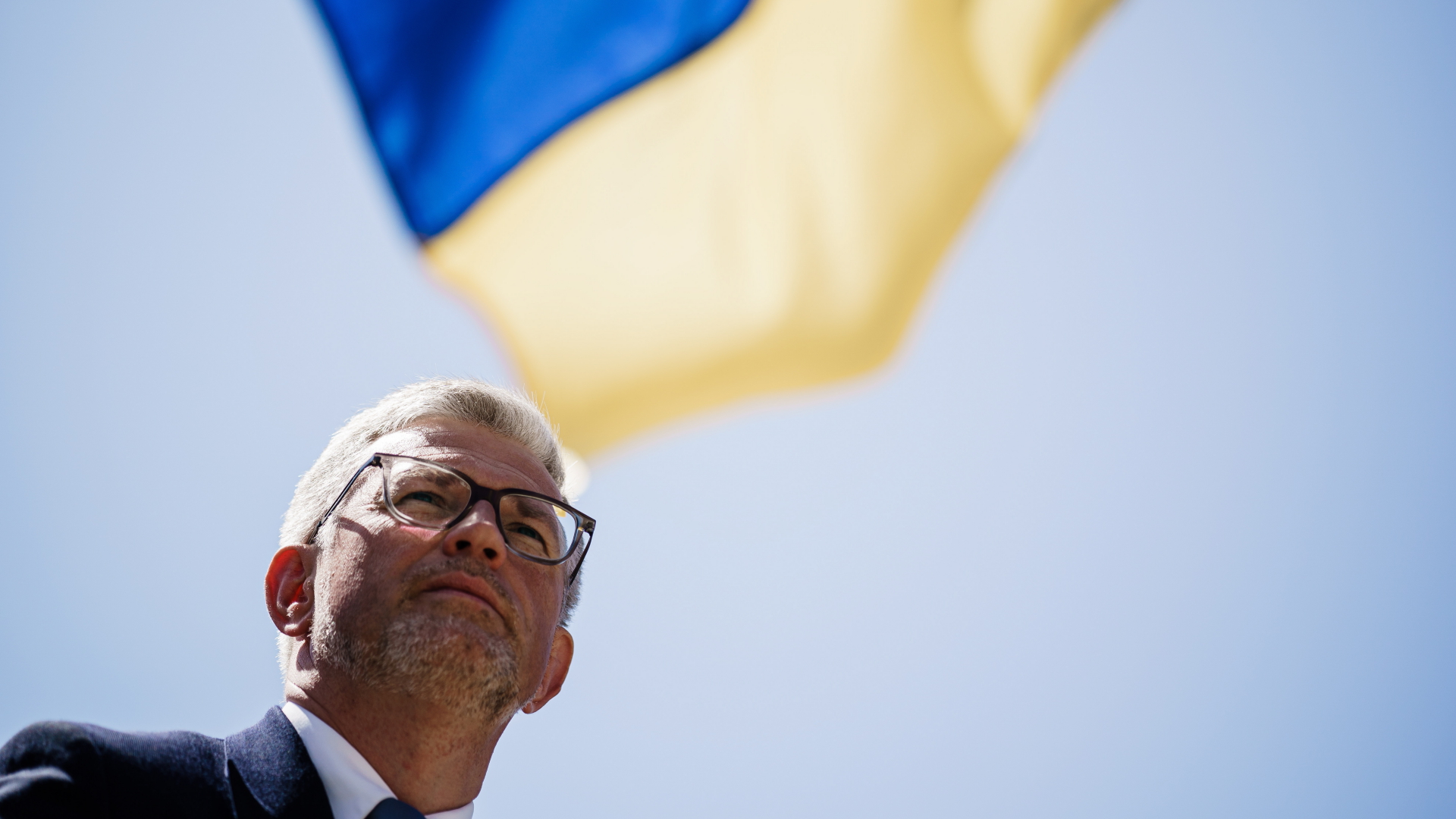 Der ukrainische Botschafter Melnyk steht vor einer ukrainischen Flagge | EPA