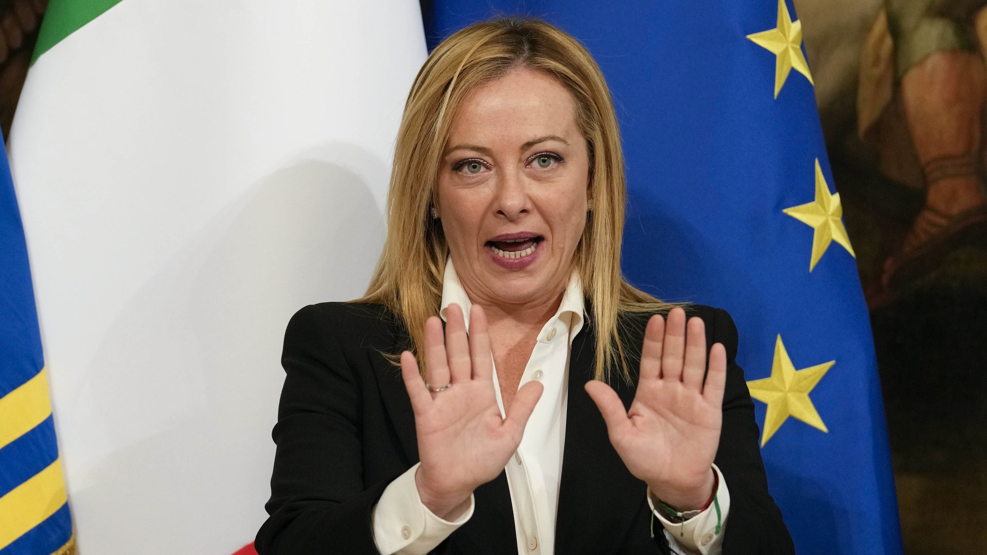 Italiens Ministerpräsidentin Meloni steht vor Fahnen Italiens und der EU | AP
