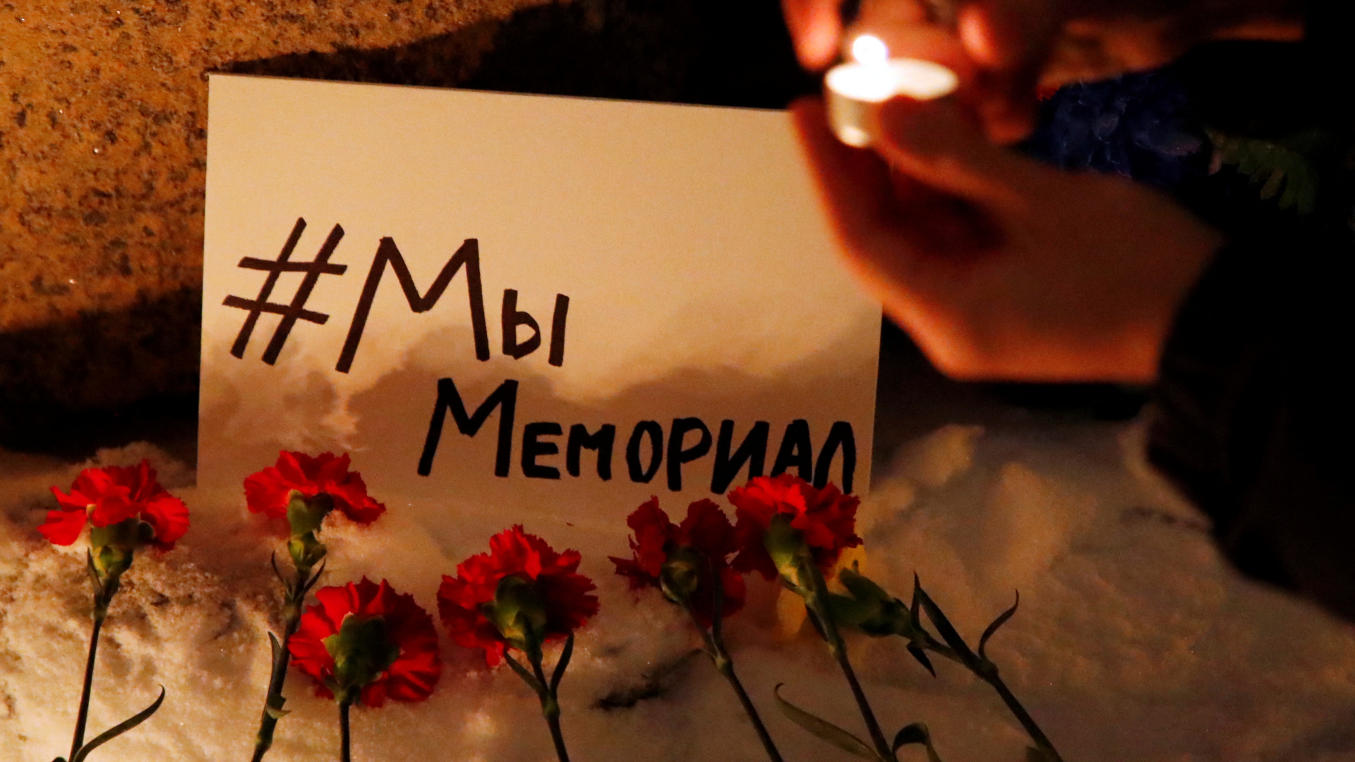 Blumen liegen vor einem Plakat mit der Aufschrift "#WirSindMemorial" in Sankt Petersburg, Russland | REUTERS