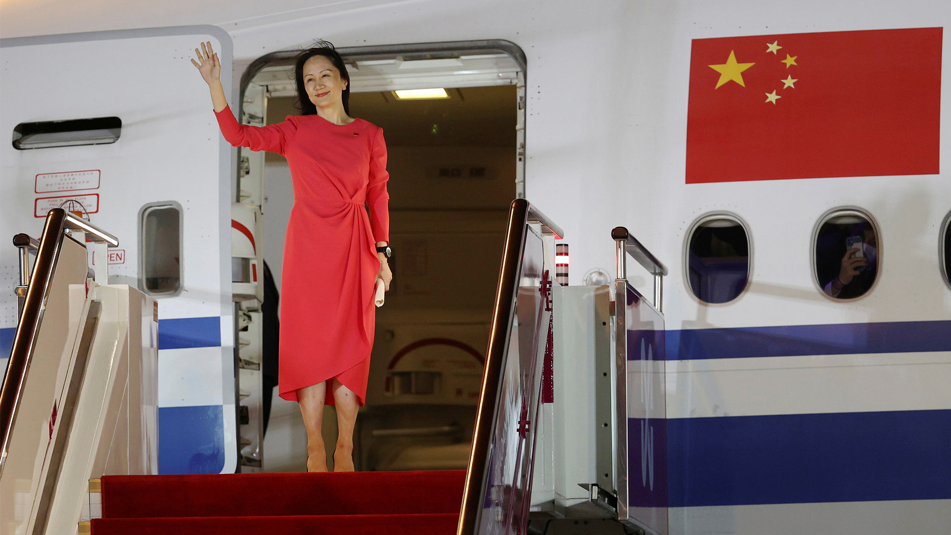 Frau Meng Wanzhou winkt als sie bei Ankunft auf dem Flughafen aus dem Flugzeug steigt.