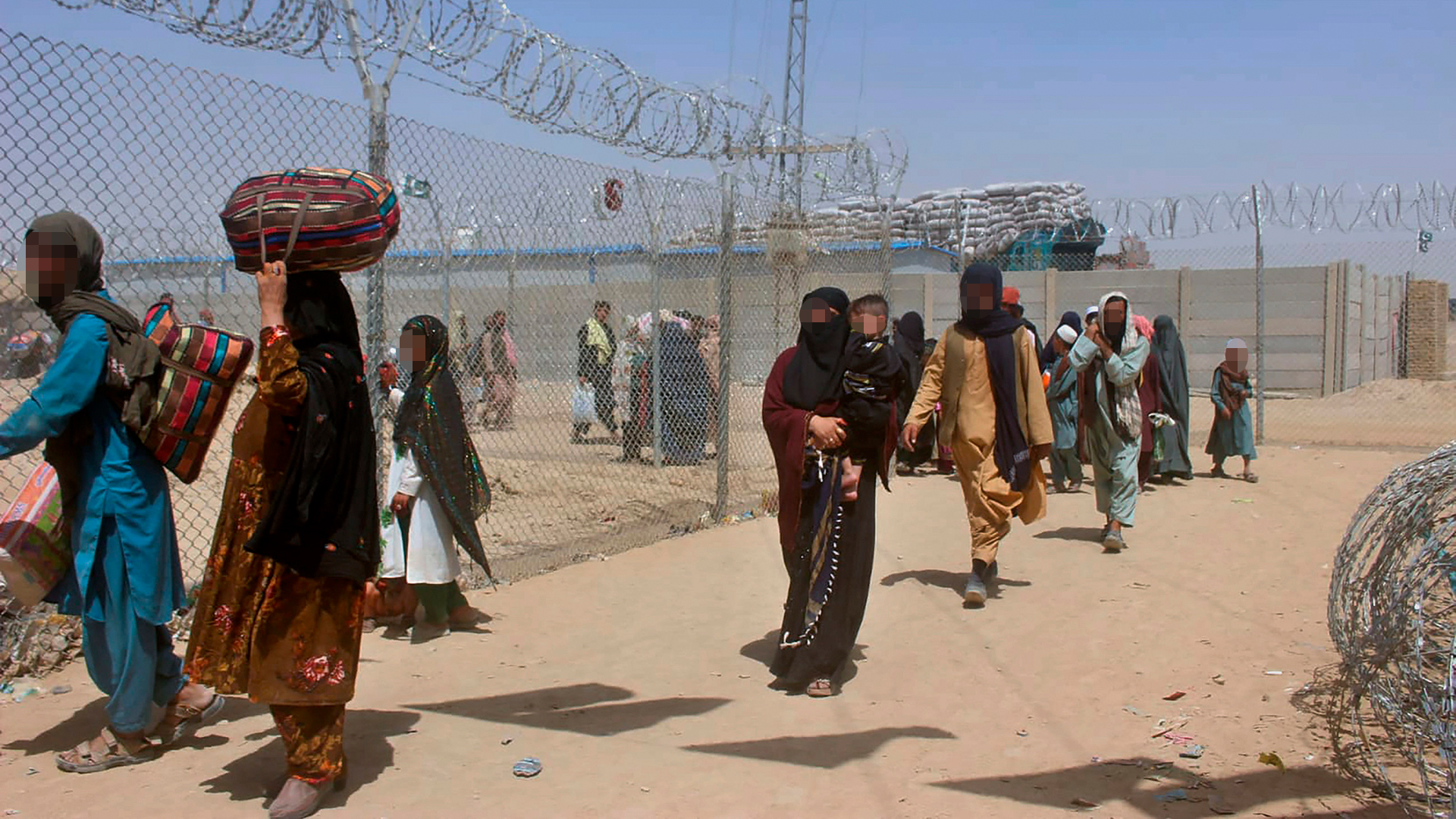 Afghanen durchschreiten eine Sicherheitsbarriere bei der Einreise nach Pakistan. | null