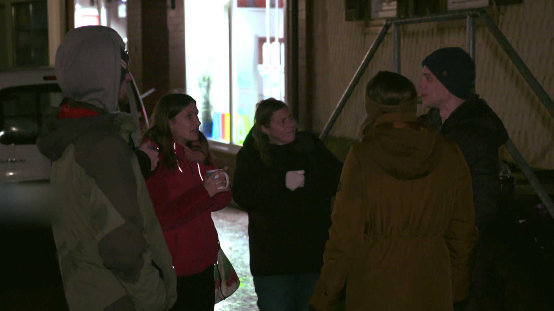 Eine Gruppe von Menschen steht auf einer Straße und spricht miteinander. | Report Mainz