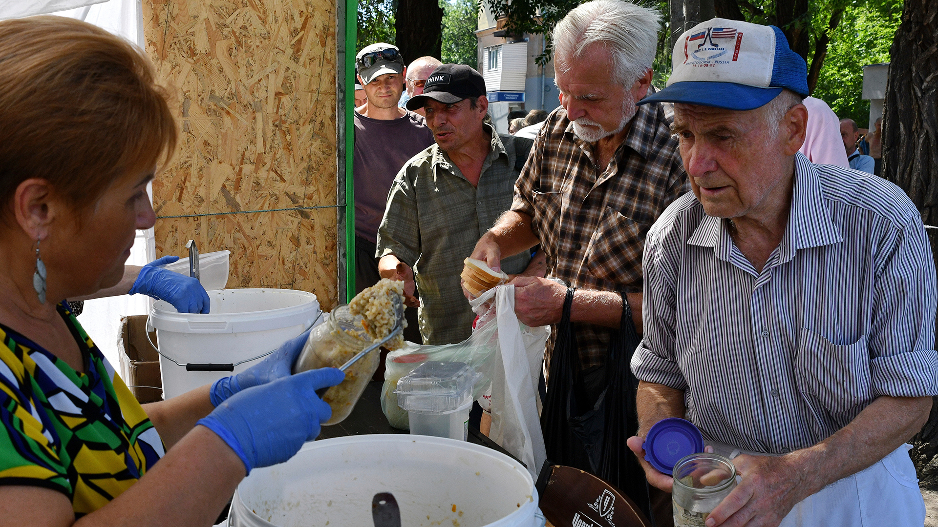 Menschen erhalten Lebensmittel an einer Verteilstelle für humanitäre Hilfe in Saporischschja (Ukraine). | dpa