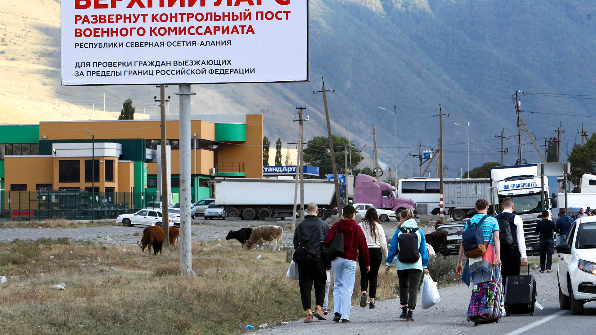 Menschen gehen zum Grenzübergang Werchny Lars zwischen Georgien und Russland. | AP