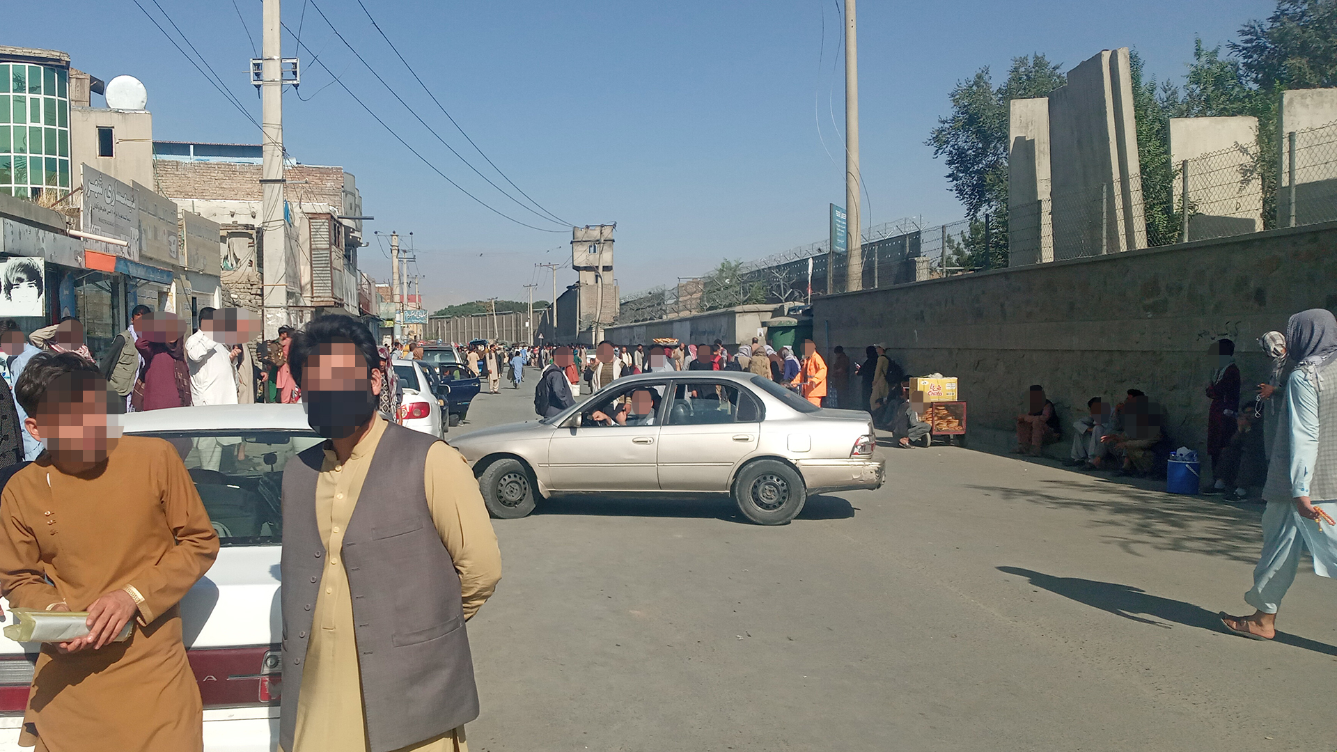 Menschen gehen auf einer Straße in der Nähe des Baron-Hotels beim Abbey Gate des Flughafens von Kabul. | via REUTERS