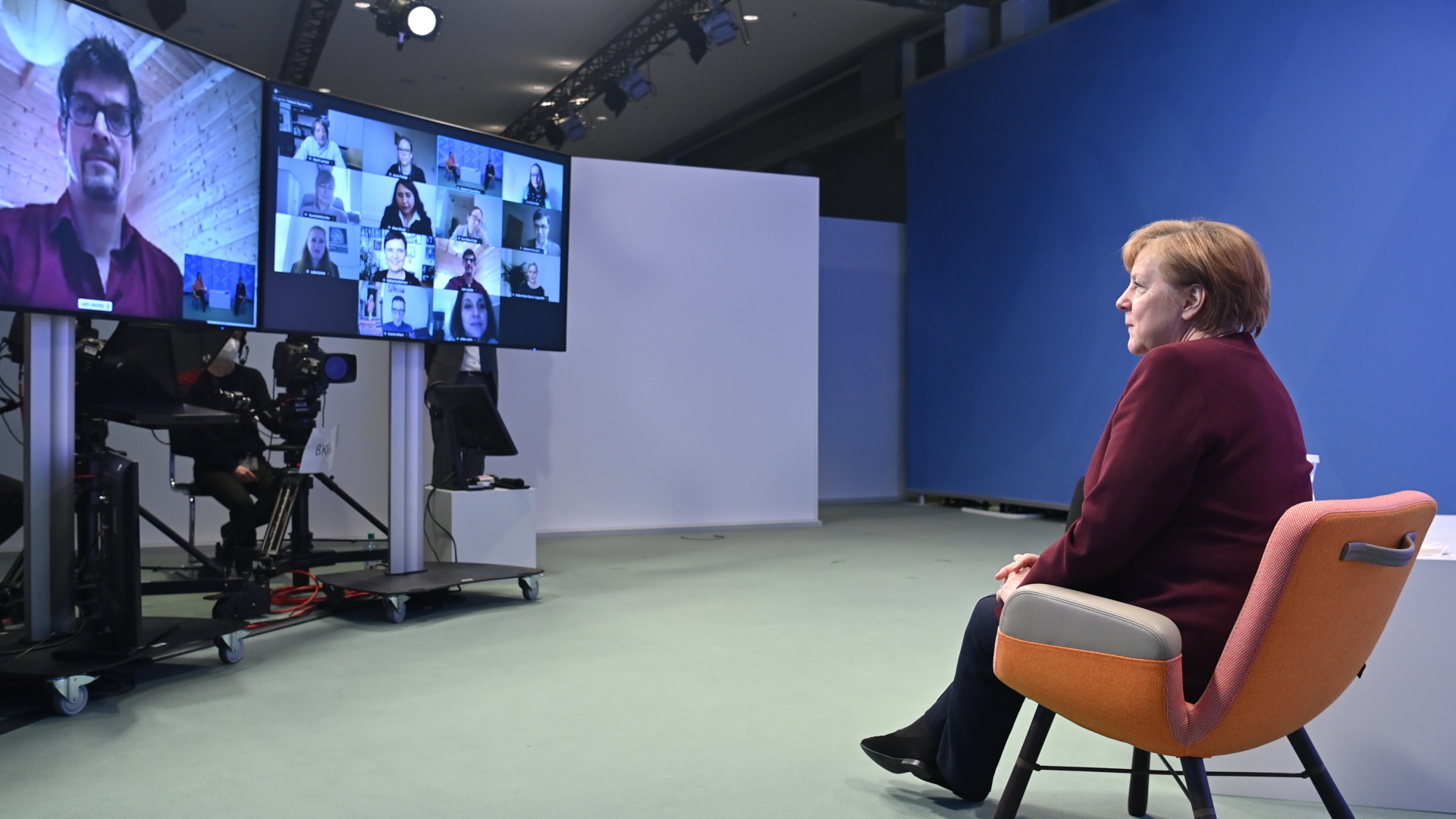 Bundeskanzlerin Angela Merkel (CDU,r) führt vom Kanzleramt aus einen virtuellen Bürgerdialog, mit Teilnehmern, die auf dem Bildschirm zu sehen sind. | dpa