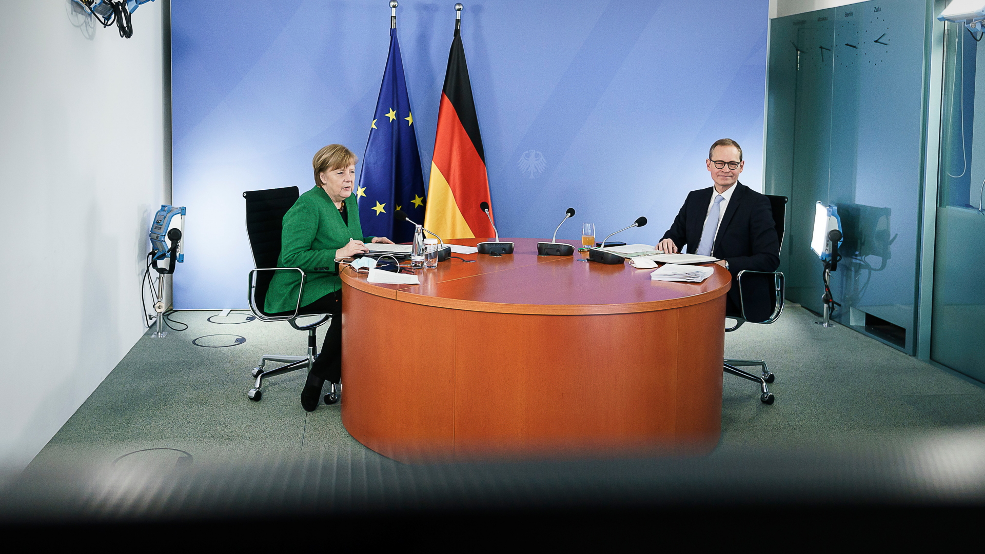 Bundeskanzlerin Angela Merkel (CDU) und Michael Müller (SPD), Regierender Bürgermeister von Berlin, sitzen zusammen während einer Videokonferenz mit den Ministerpräsidenten der Länder zum weiteren Vorgehen in der Corona-Pandemie. | dpa