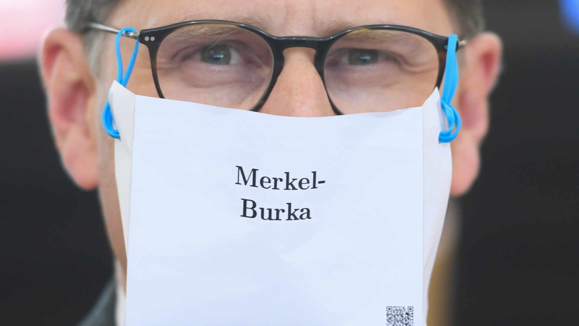 Ein AfD-Politiker trägt einen Mundschutz mit der Aufschrift "Merkel-Burka". | dpa