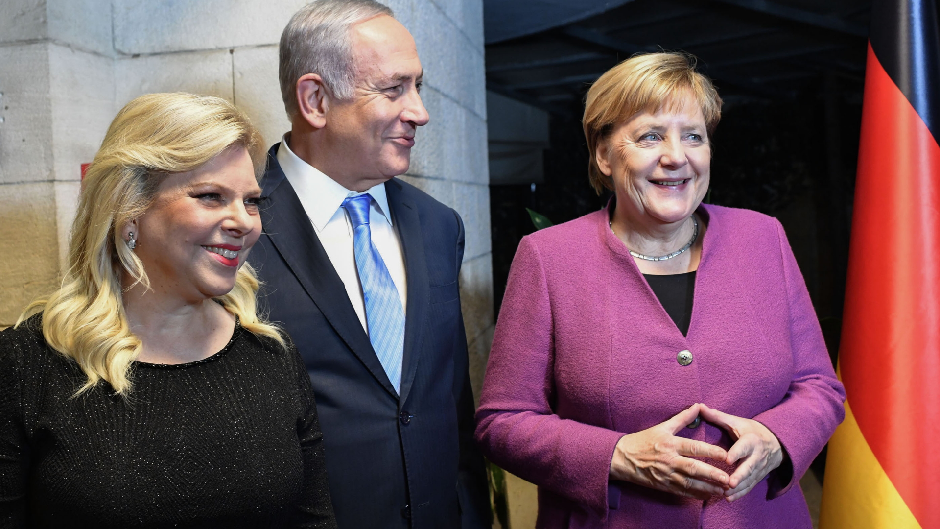 Bundeskanzlerin Merkel steht lächeln neben Israels Premier Netanyahu und dessen Frau. | Bildquelle: dpa