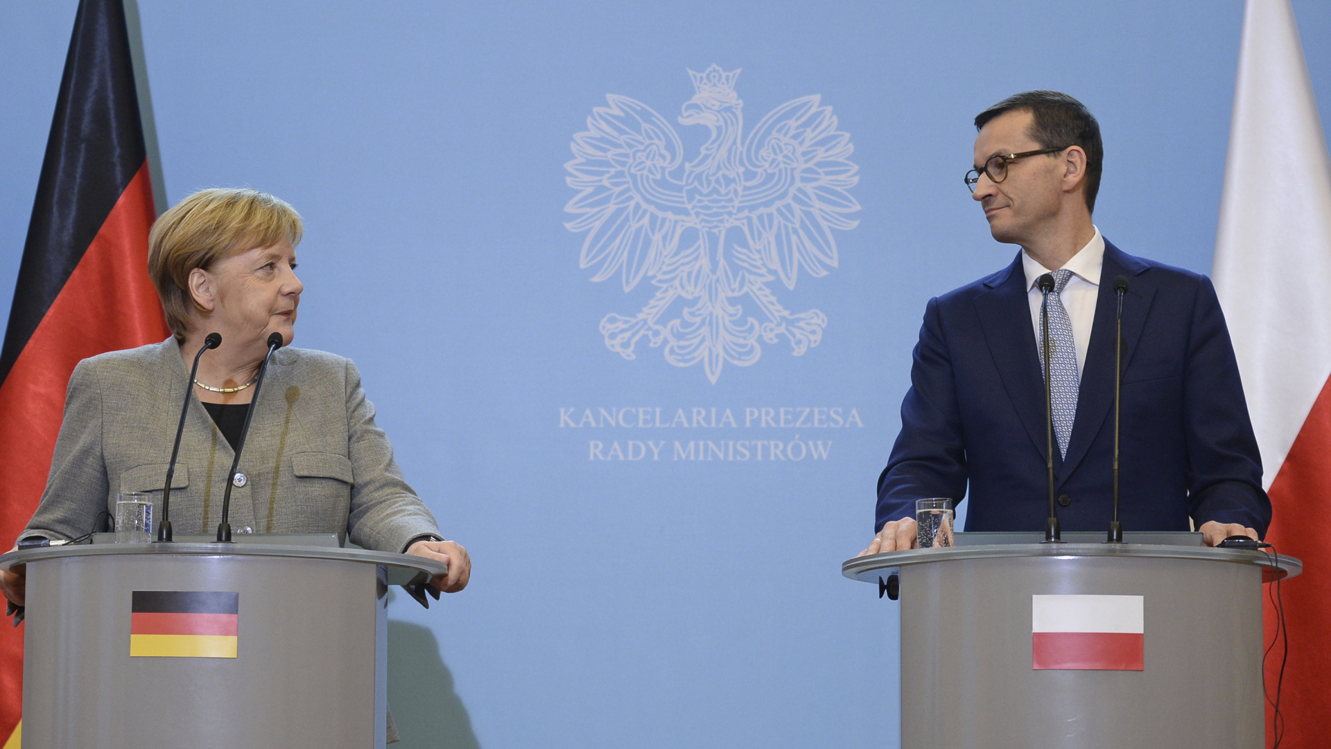 Kanzlerin Angela Merkel und Polens Ministerpräsident Mateusz Morawiecki an Rednerpulten. | Bildquelle: AP