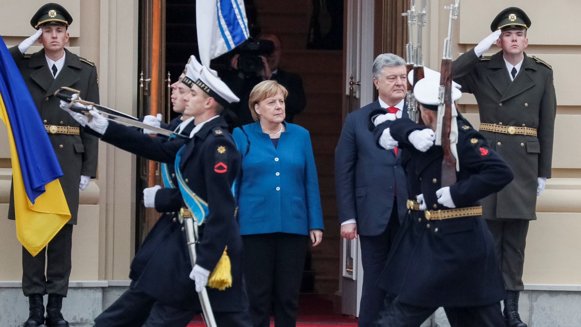Die ukrainische Ehrengarde zieht an Kanzlerin Merkel und Präsident Poroschenko vorbei. | Bildquelle: REUTERS