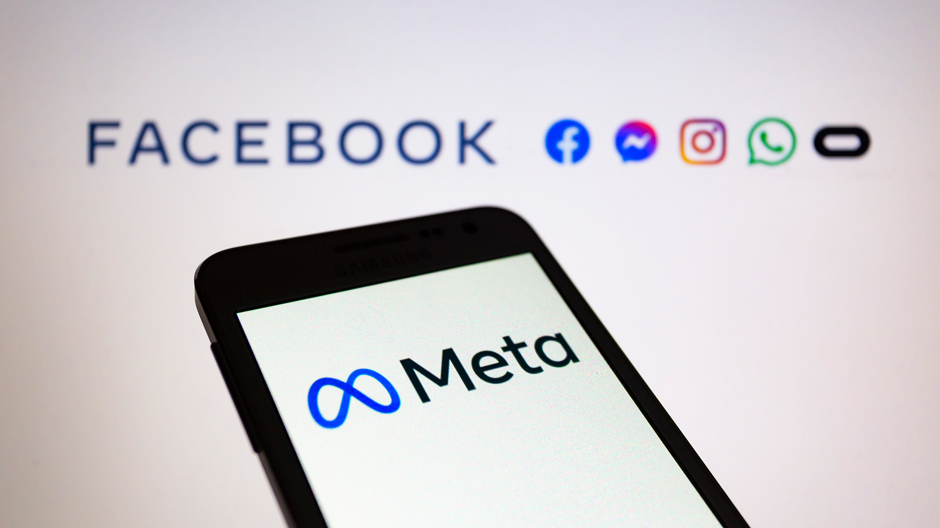 Das Logo von Meta wird auf einem Smartphone angezeigt. Im Hintergrund sind die Logos von Facebook, Messenger, Instagram, Whatsapp und Oculus zu sehen. | dpa