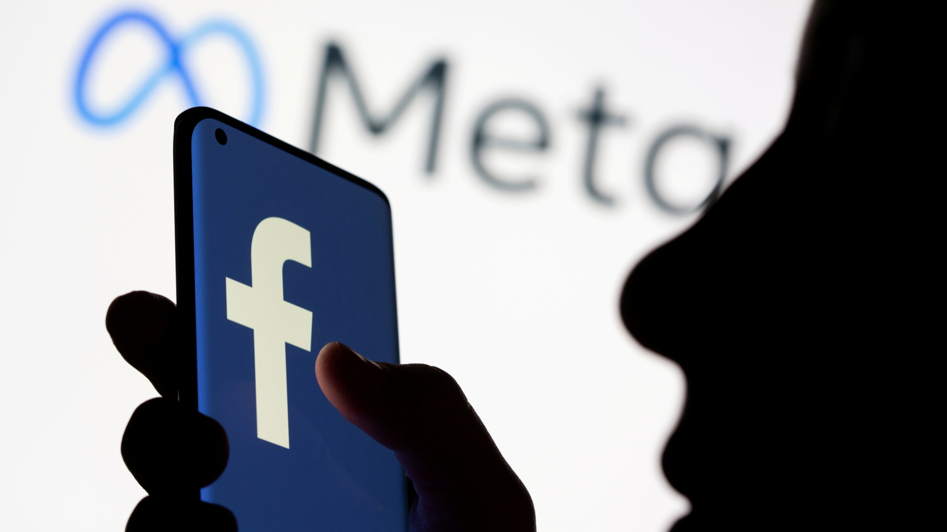 Facebook-Logo auf einem Smartphone mit Logo des Meta-Konzerns im Hintergrund | REUTERS