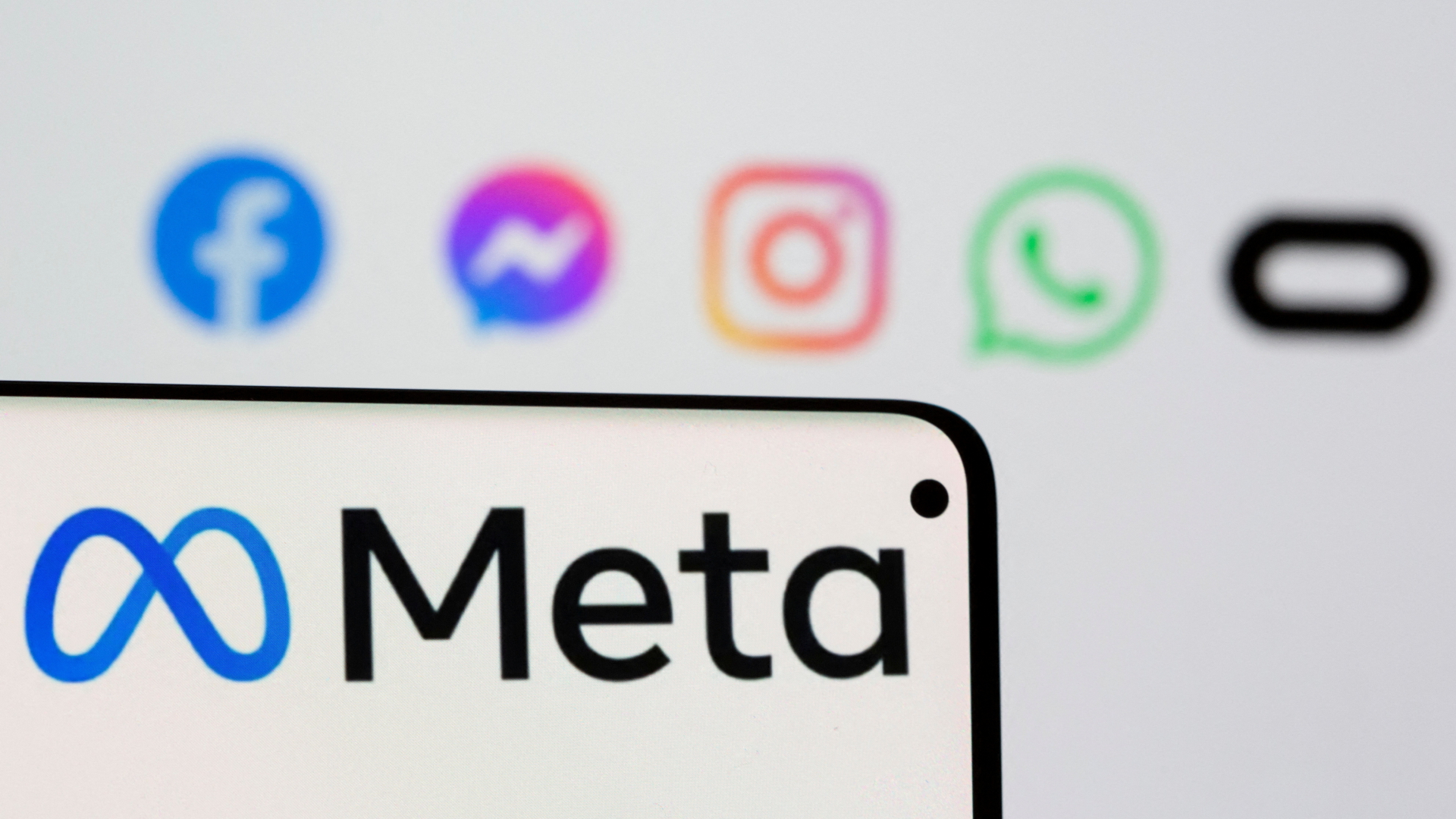 Das Logo Meta auf einem Smartpone vor den Logos von Facebook, Messenger, Intagram, Whatsapp und Oculus