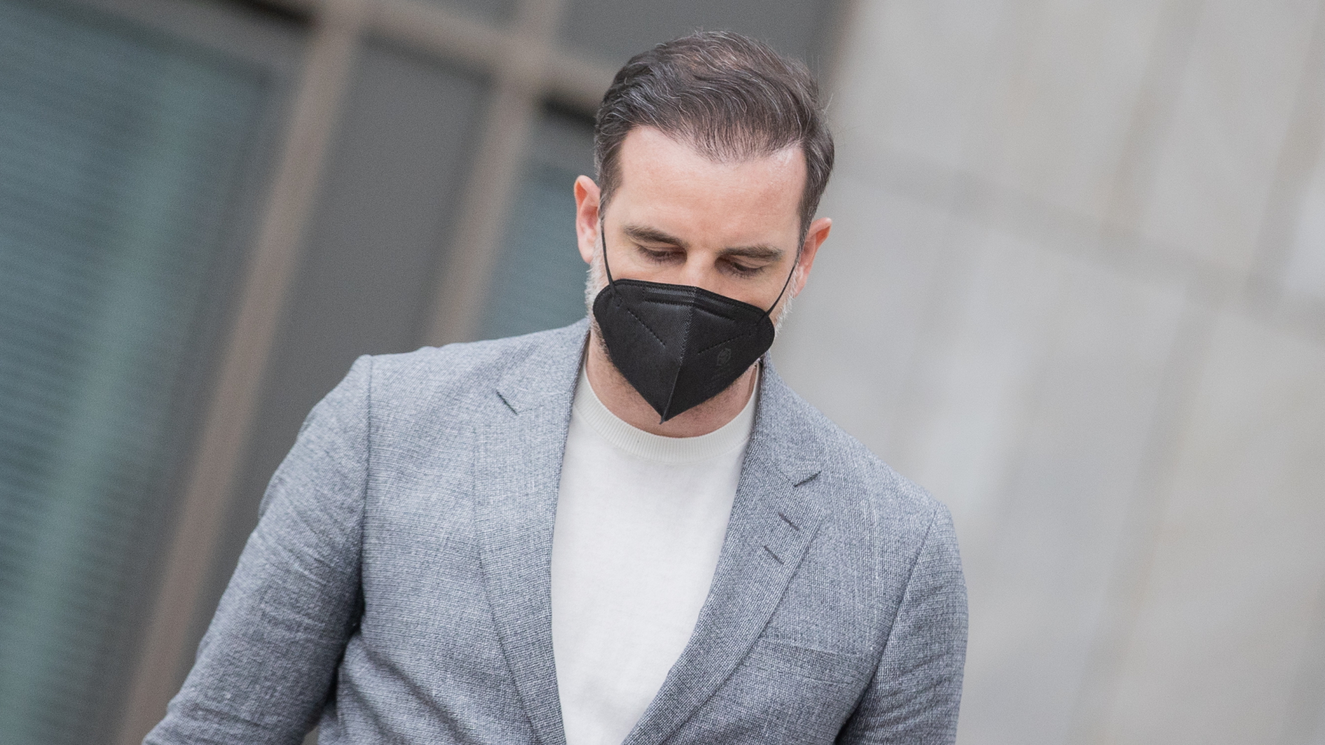Der frühere Nationalspieler Christoph Metzelder verlässt nach dem Urteilsspruch gegen ihn das Amtsgericht Düsseldorf. Er blickt zu Boden und trägt eine schwarze Corona-Schutzmaske. | dpa