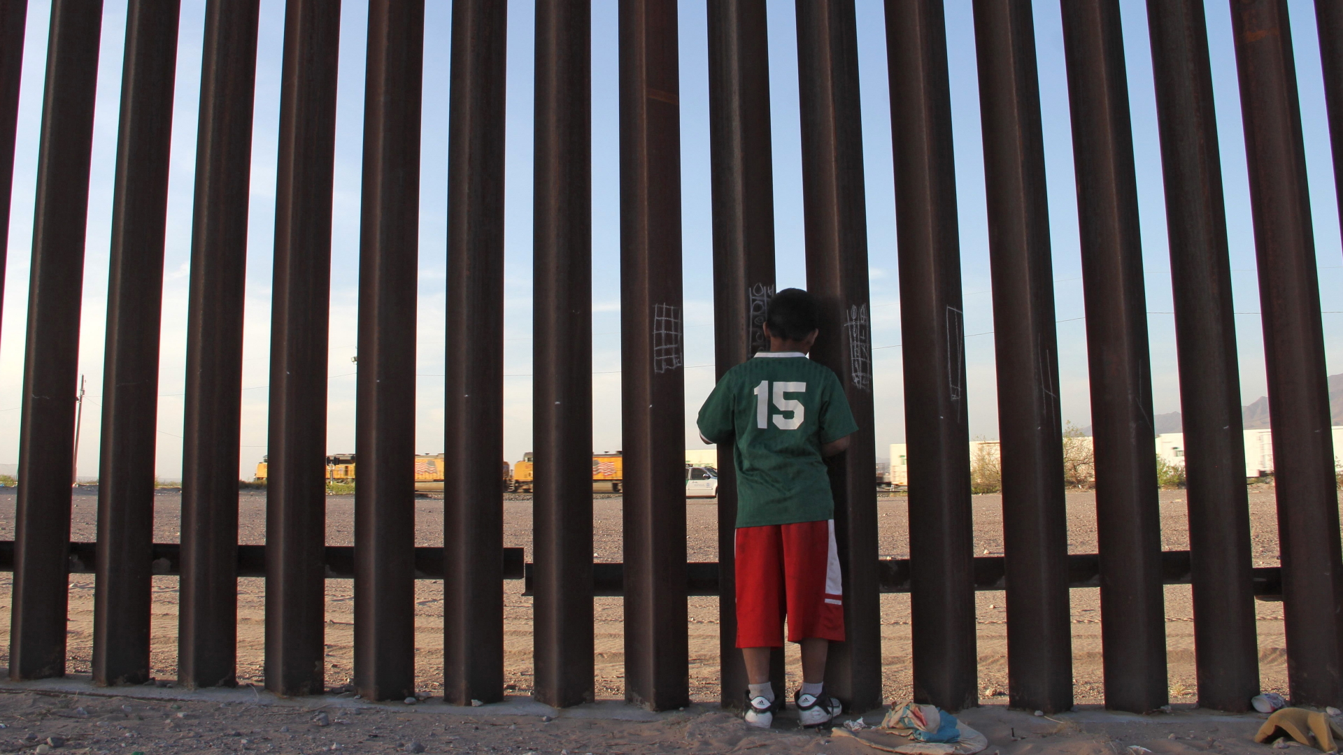 Ein Junge steht auf der mexikanischen Seite der Grenze und schaut in die USA. | Bildquelle: AFP